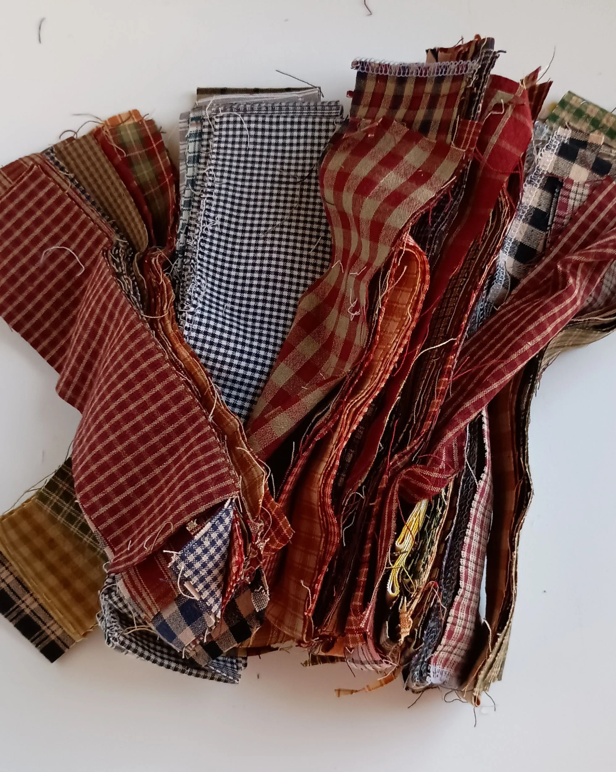 A pile of strips and scraps of homespun fabric