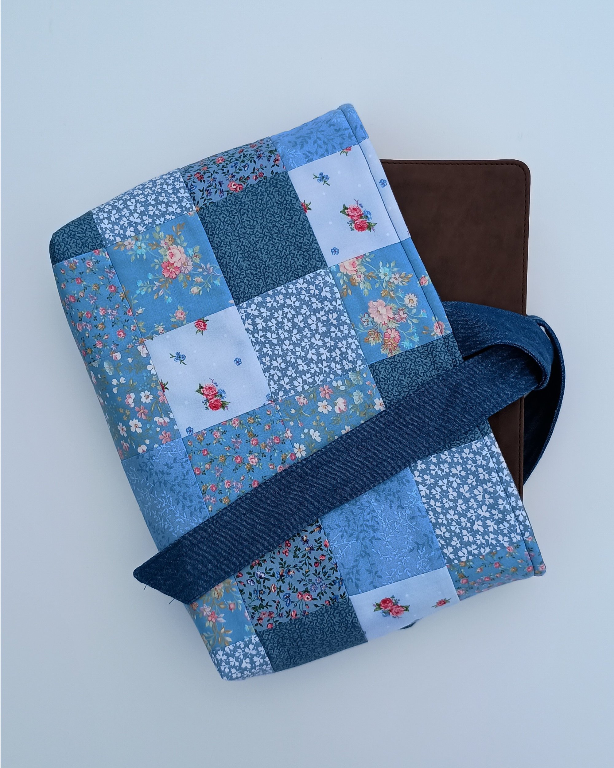 A quilted Bible Sleeve made from blue fabrics in a patchwork style