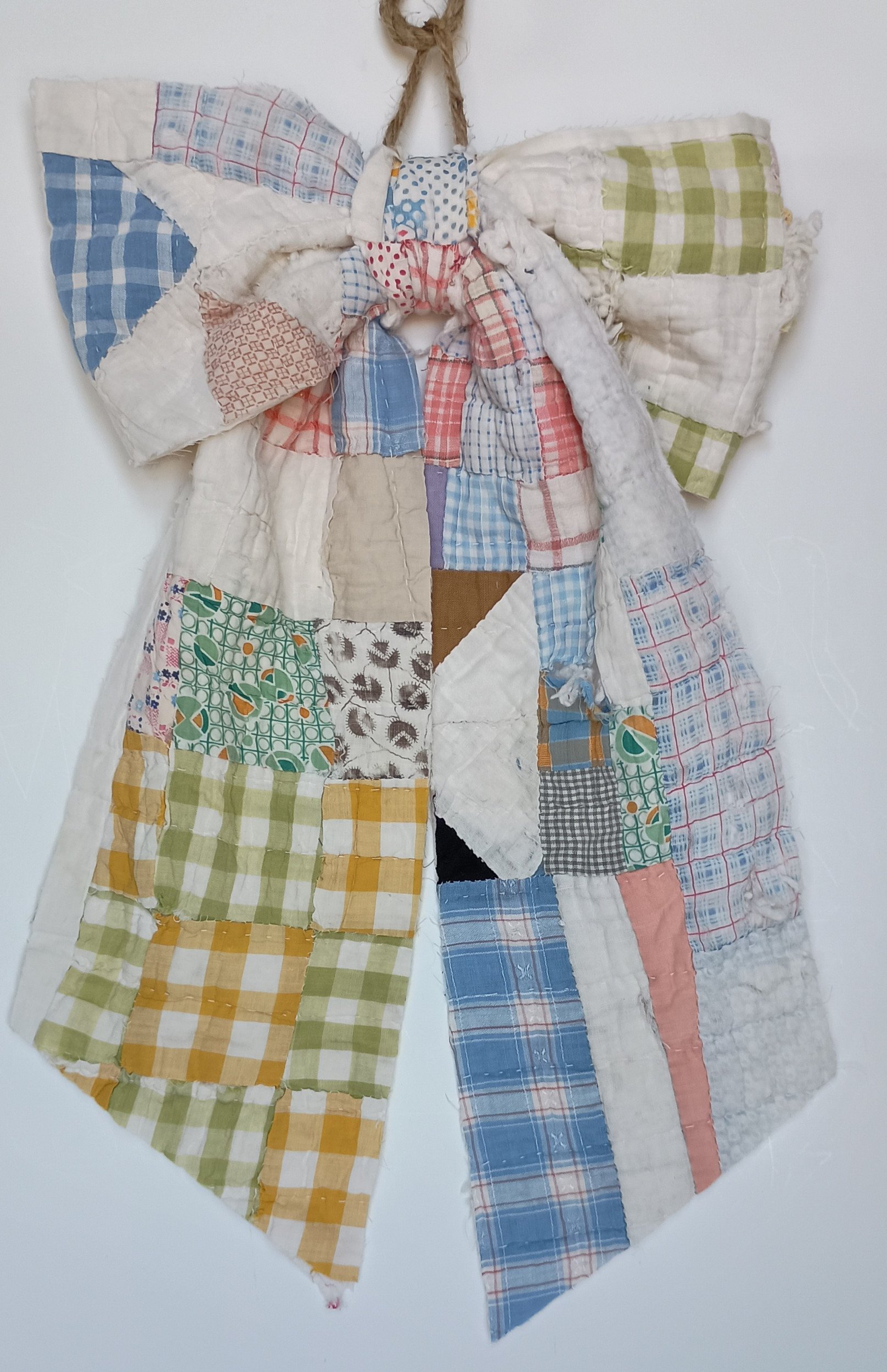 A decorative bow made from a tattered antique quilt