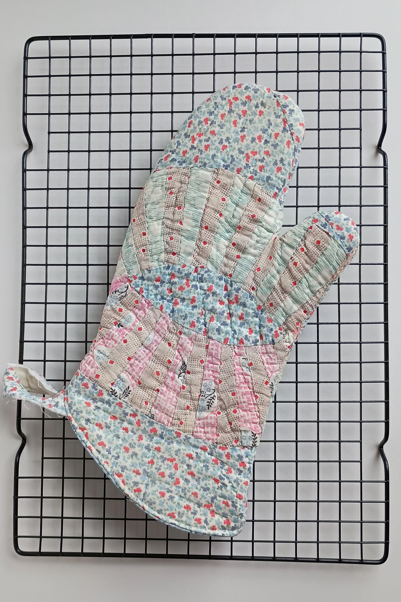 An oven mitt made from an antique quilt