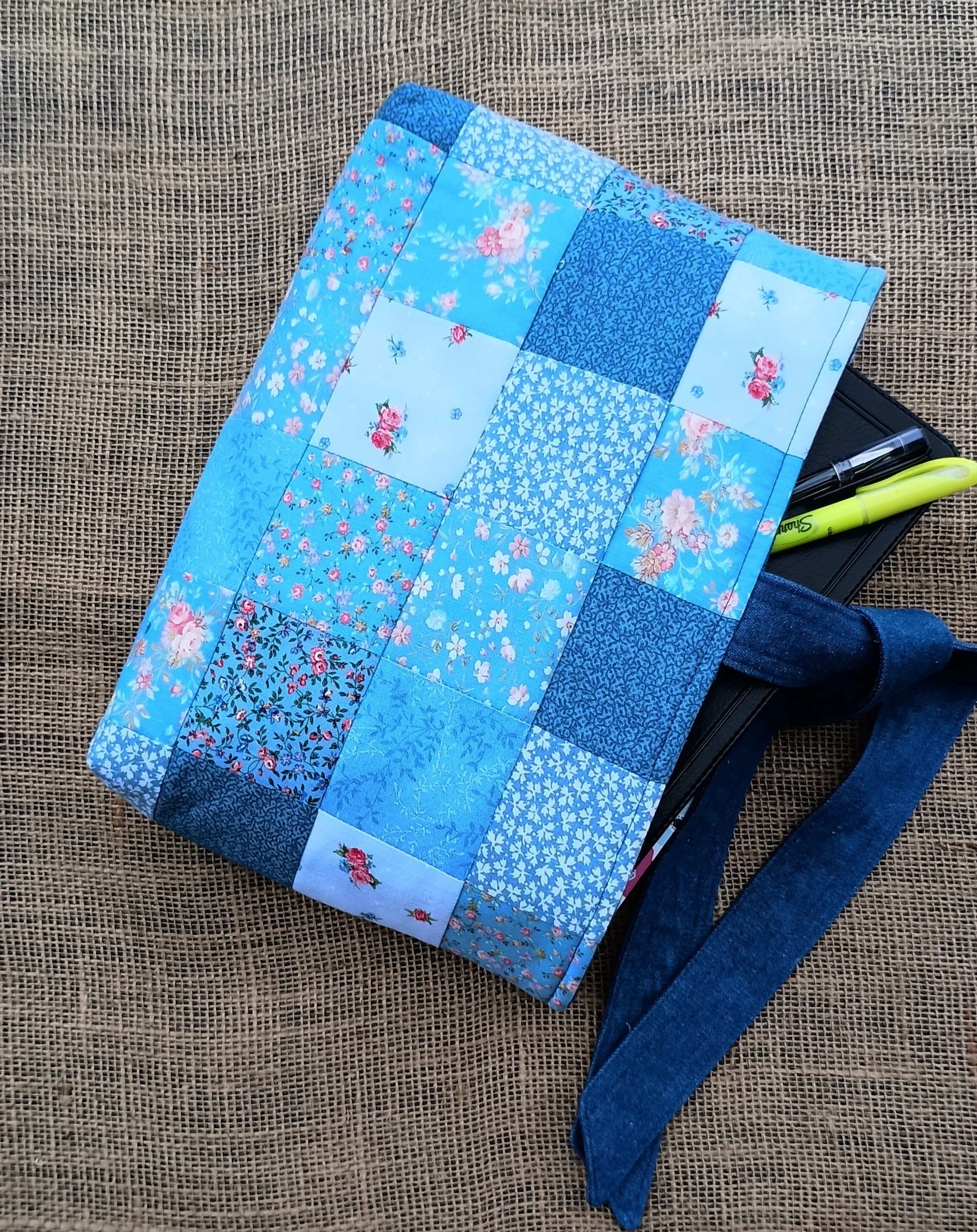 A quilted Bible Sleeve made from blue fabrics in a patchwork style