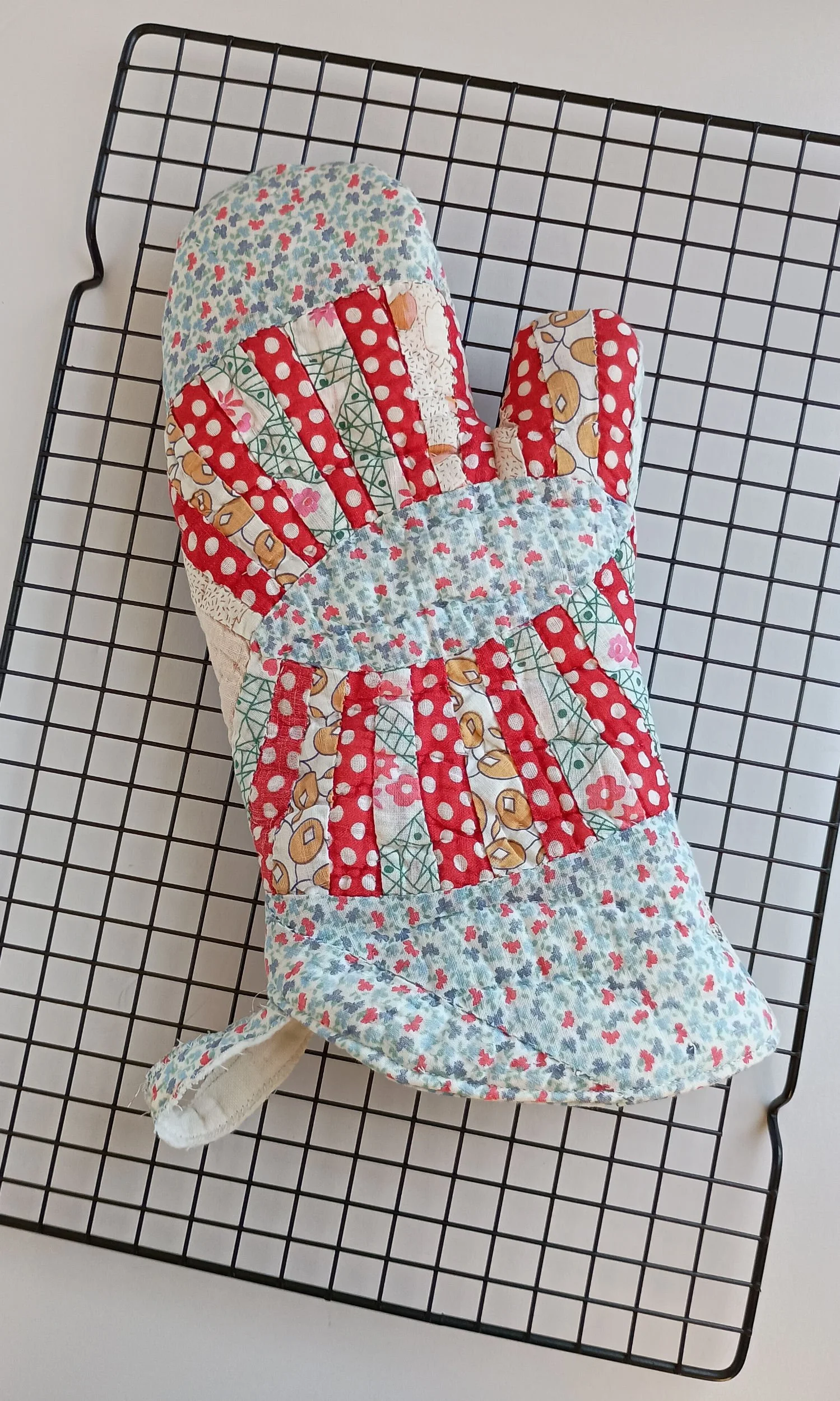 An oven mitt made from an antique quilt