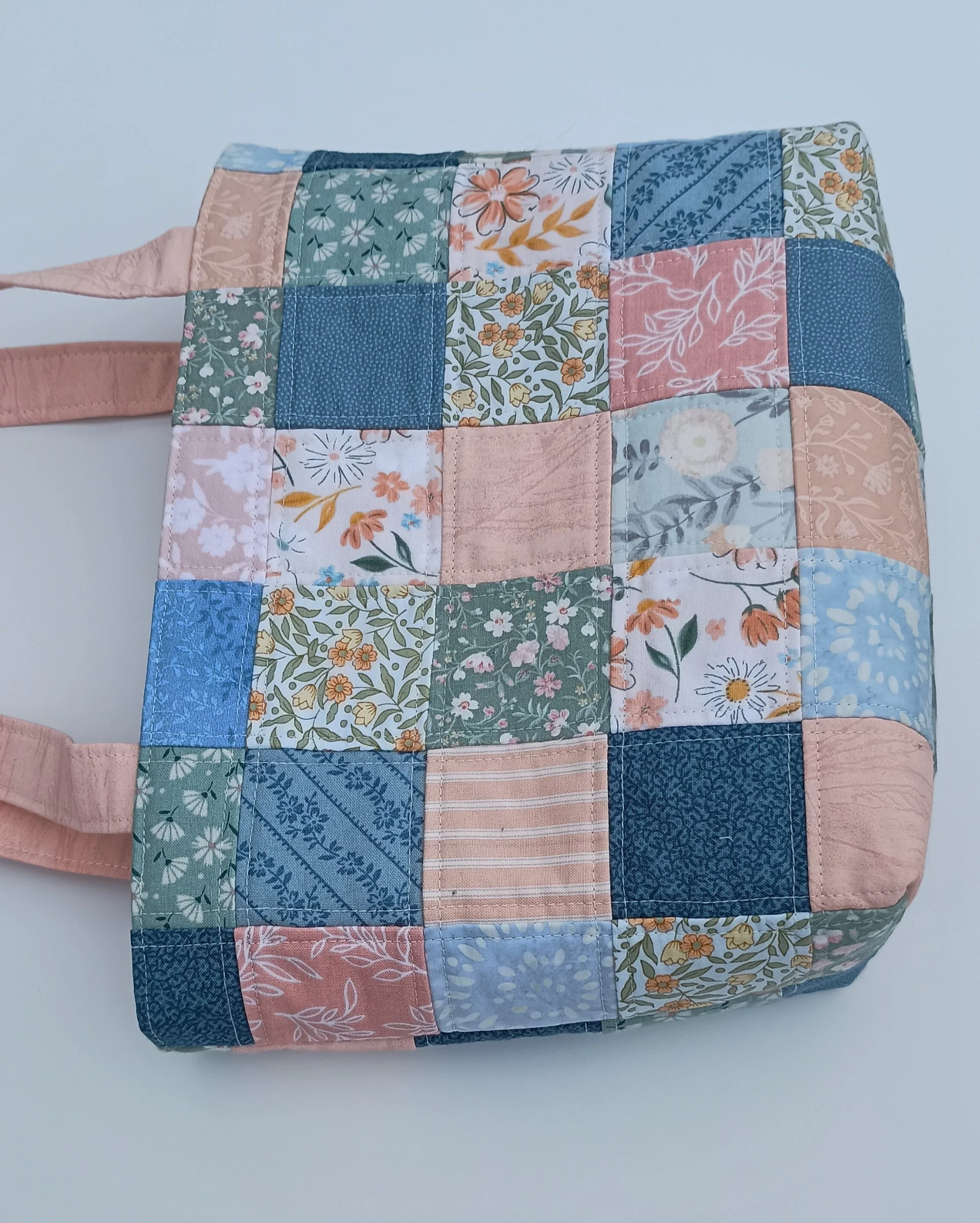 A quilted patchwork Bible Bag made from peach, green, and blue fabrics