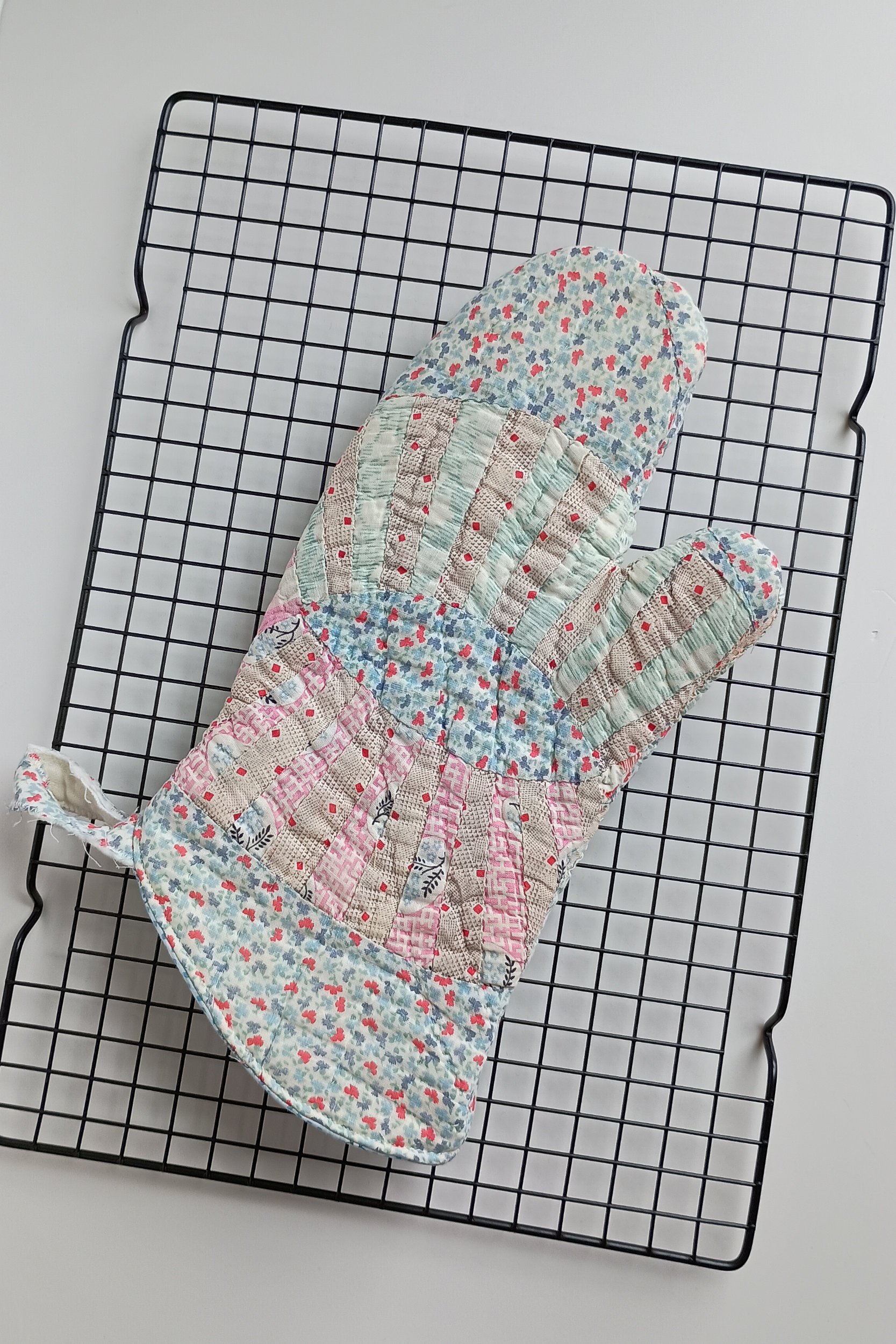 An oven mitt made from an antique quilt