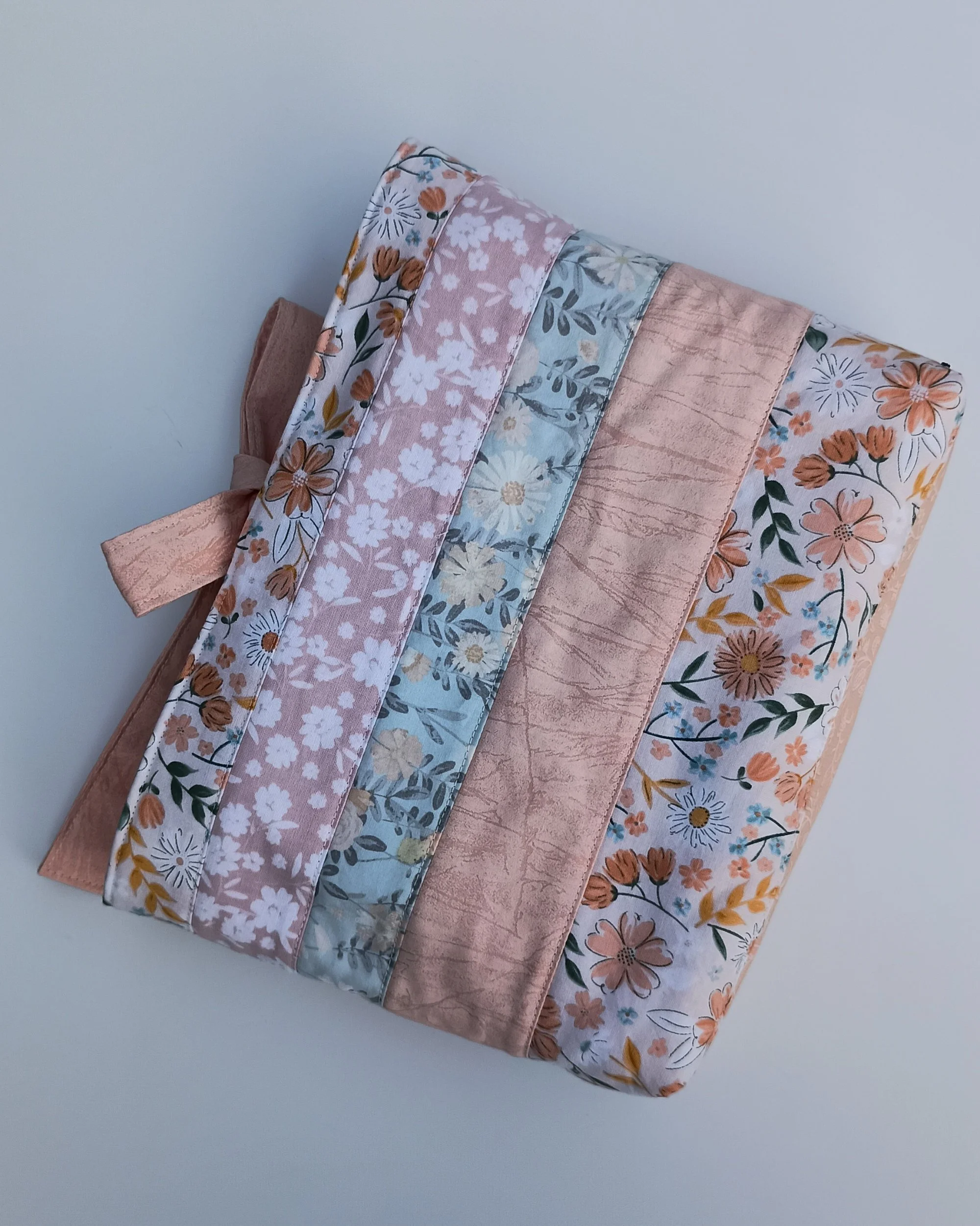 A quilted Bible Sleeve made from peach and blue floral fabrics