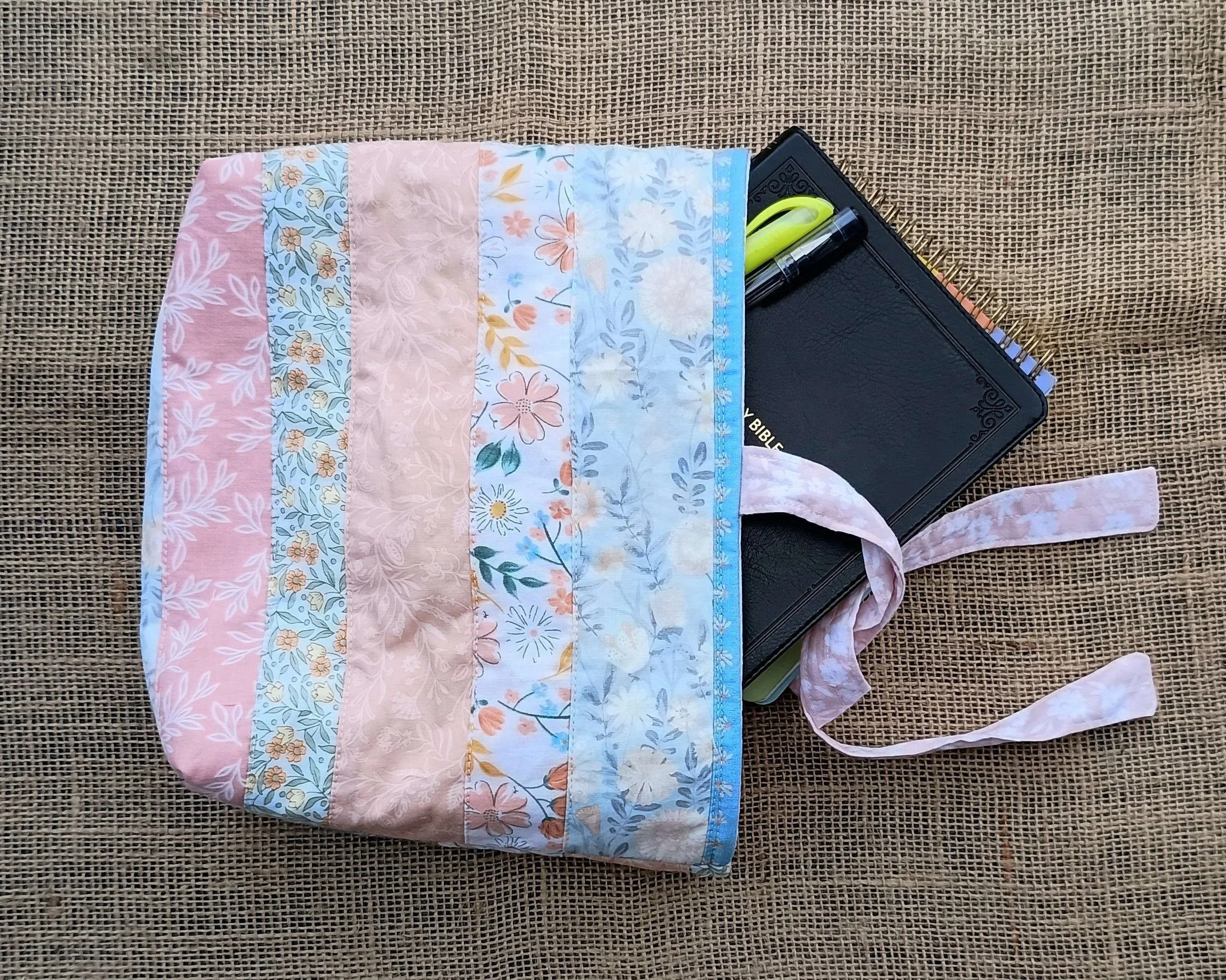 A quilted Bible Sleeve made from peach, green, and blue floral fabrics