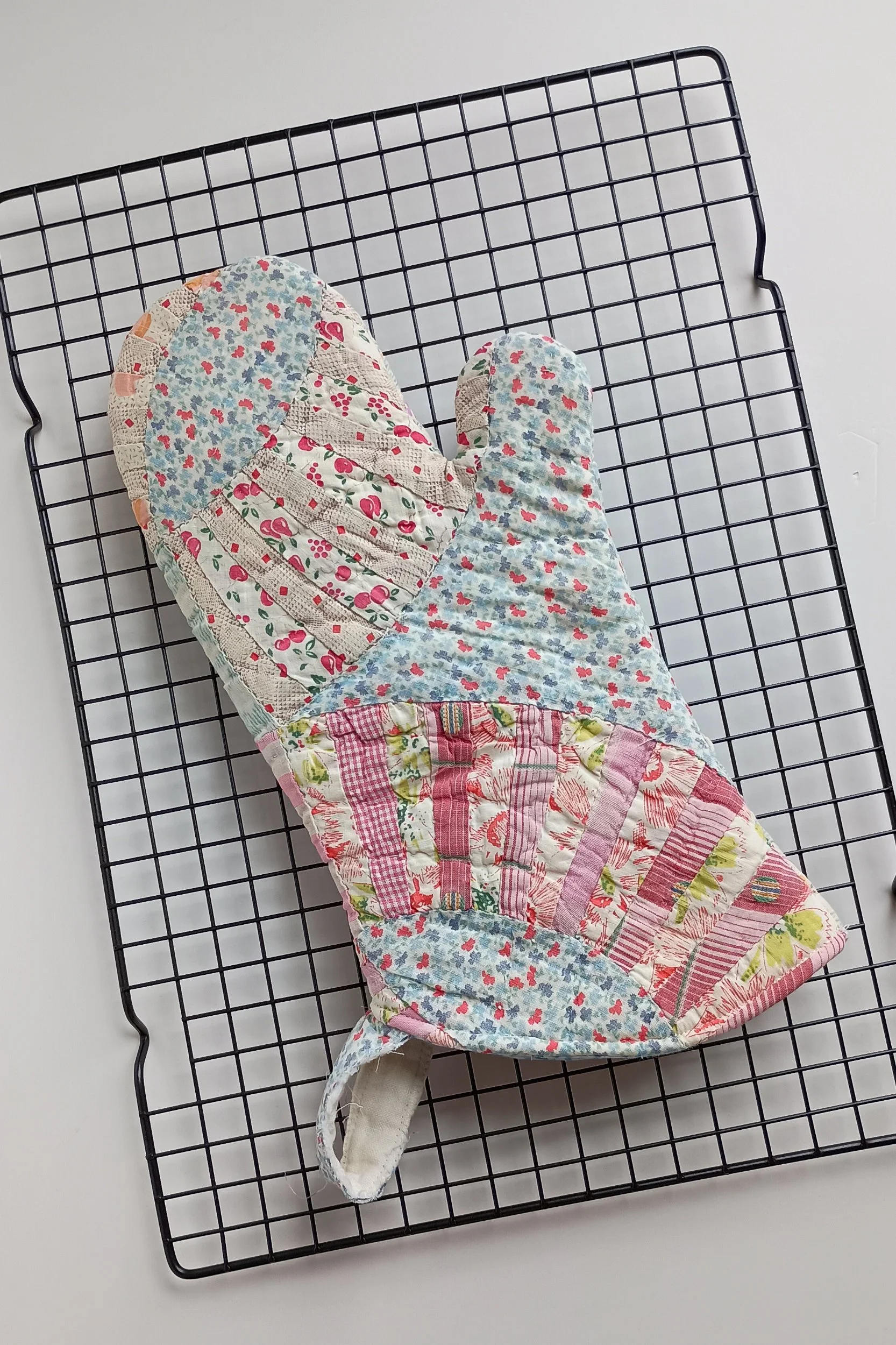 An oven mitt made from an antique quilt
