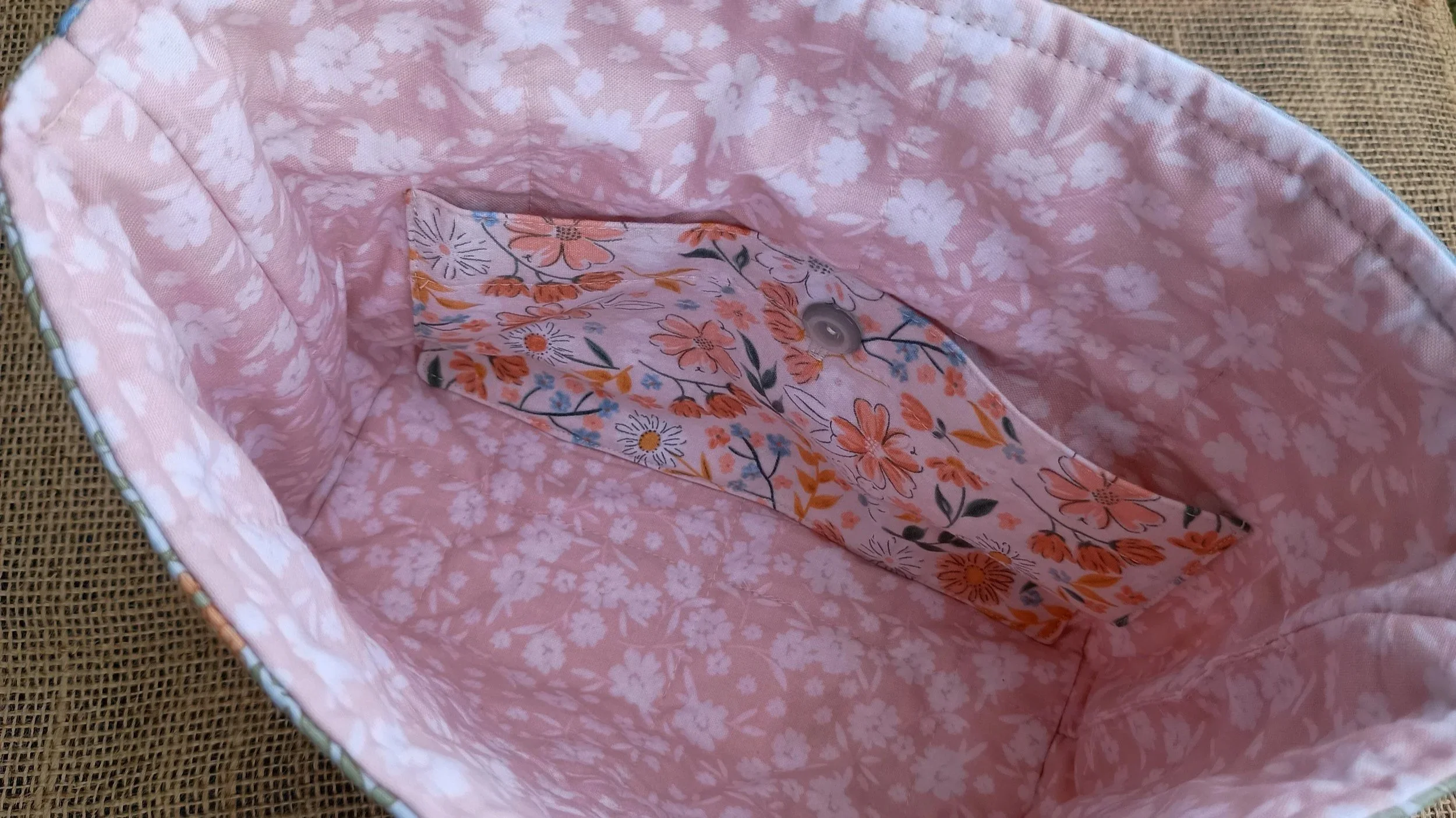 A quilted Bible Sleeve made from peach, green, and blue floral fabrics