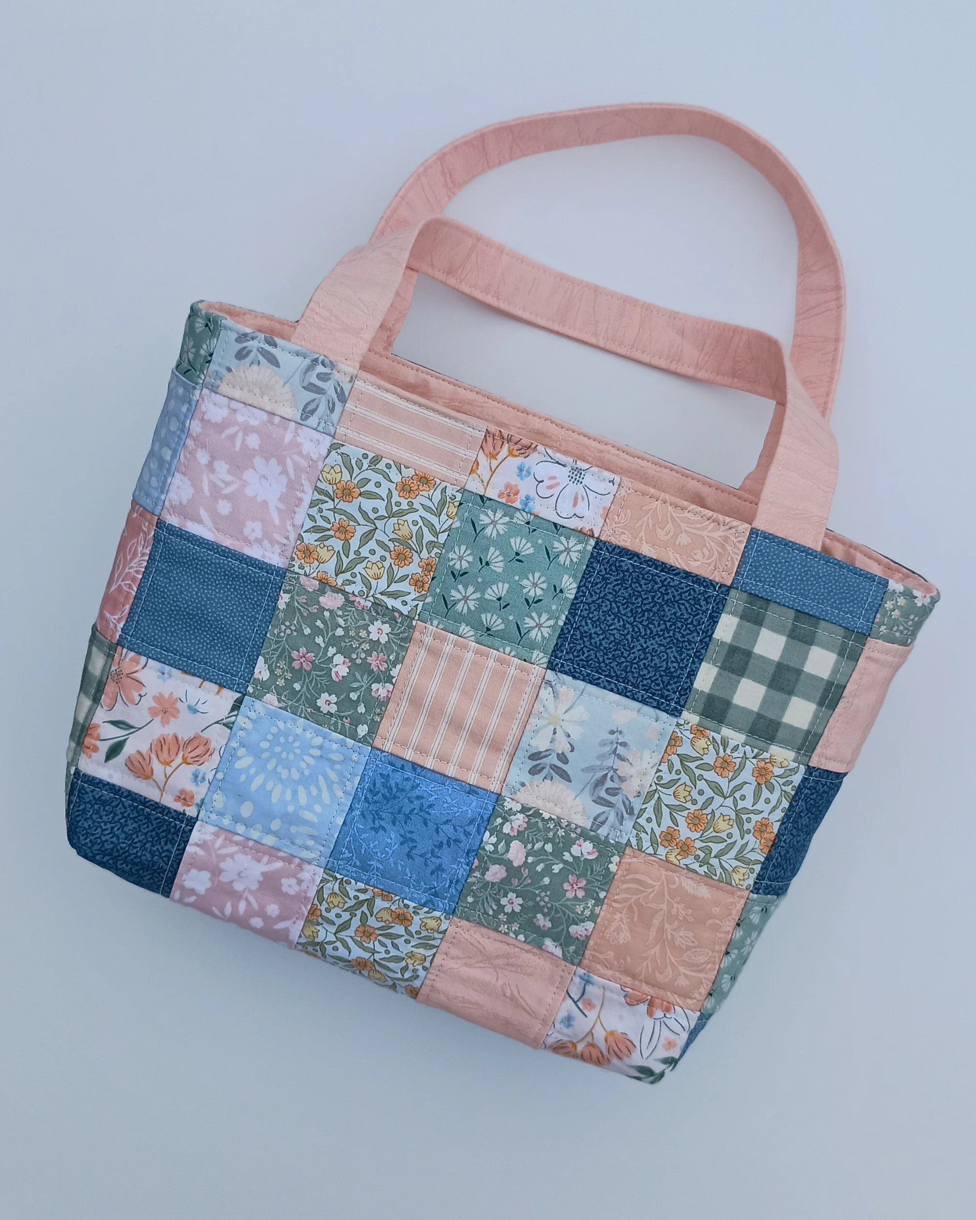 A quilted patchwork Bible Bag made from peach, green, and blue fabrics