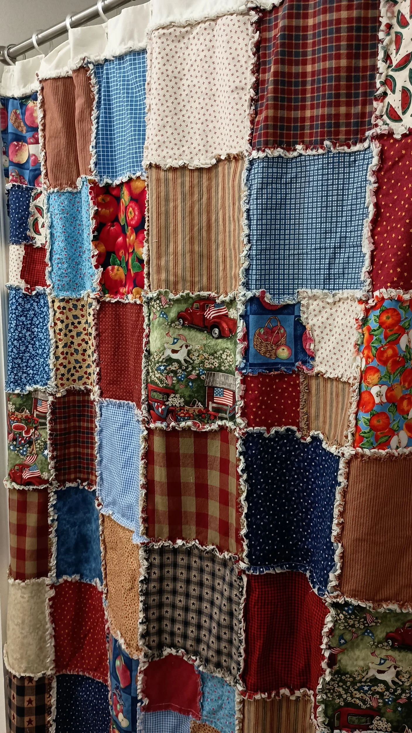 A patchwork shower curtain featuring Americana themed squares and colors