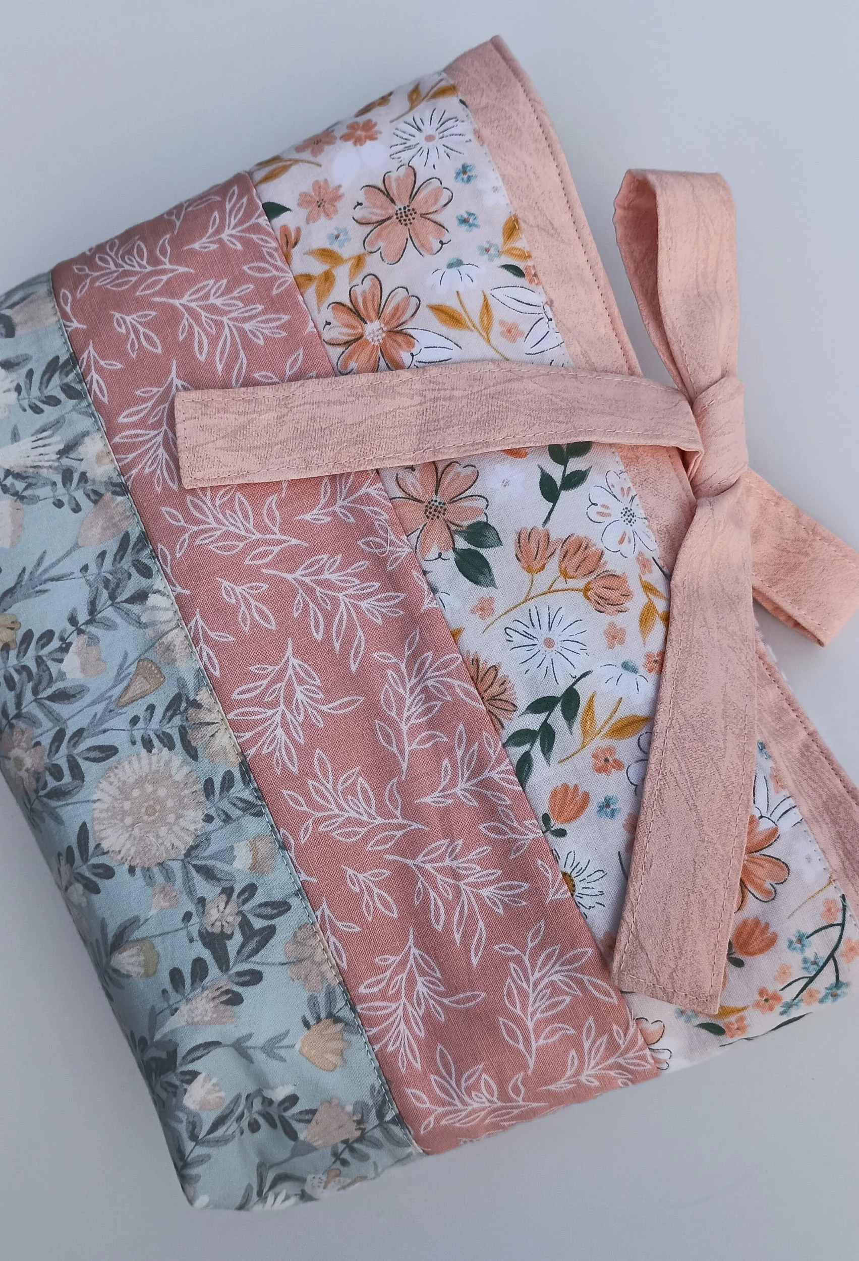 A quilted Bible Sleeve made from peach and blue floral fabrics