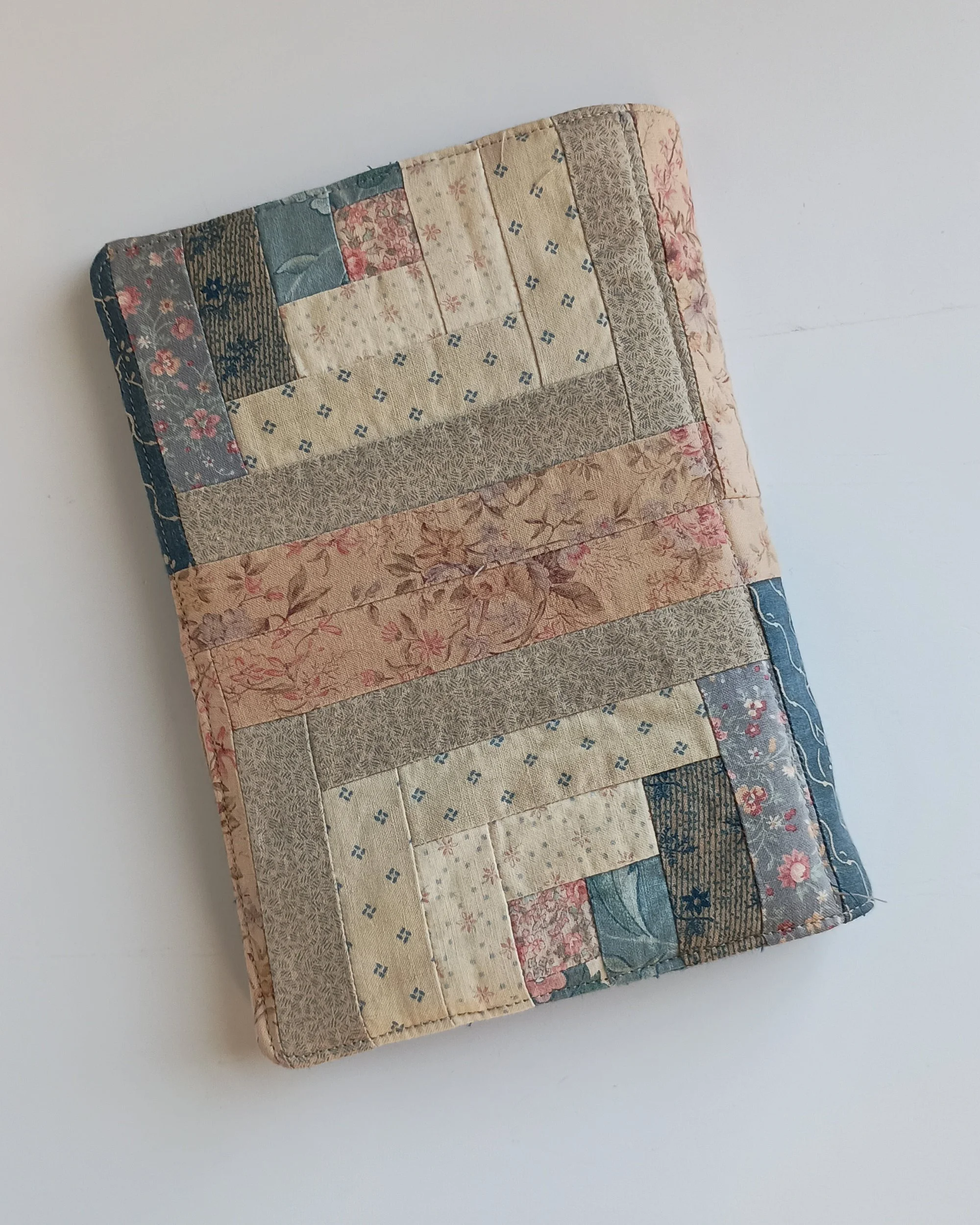The back side of a notepad cover made from a vintage log cabin quilt top