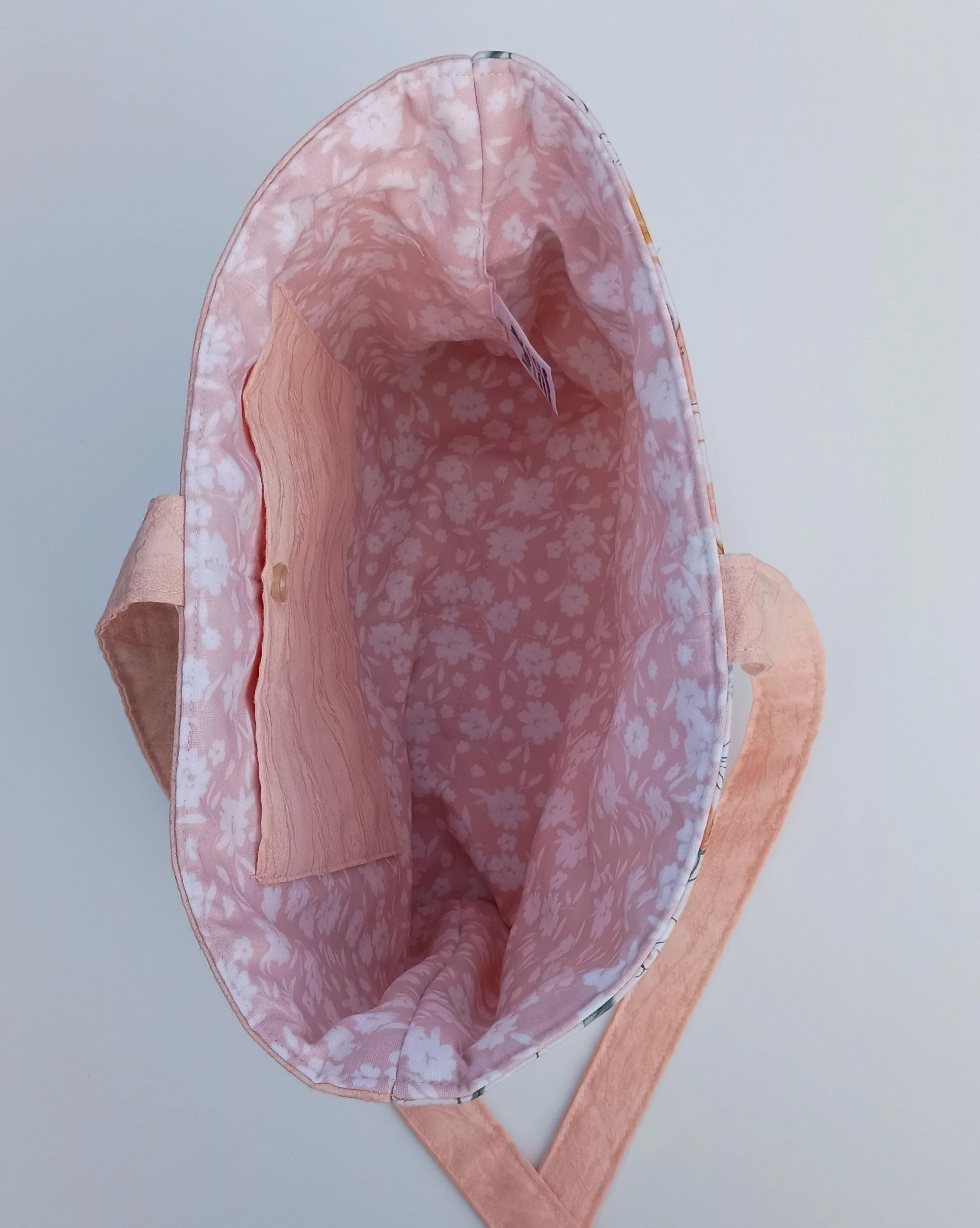 An inside view of a quilted Bible Sleeve made from peach and blue floral fabrics