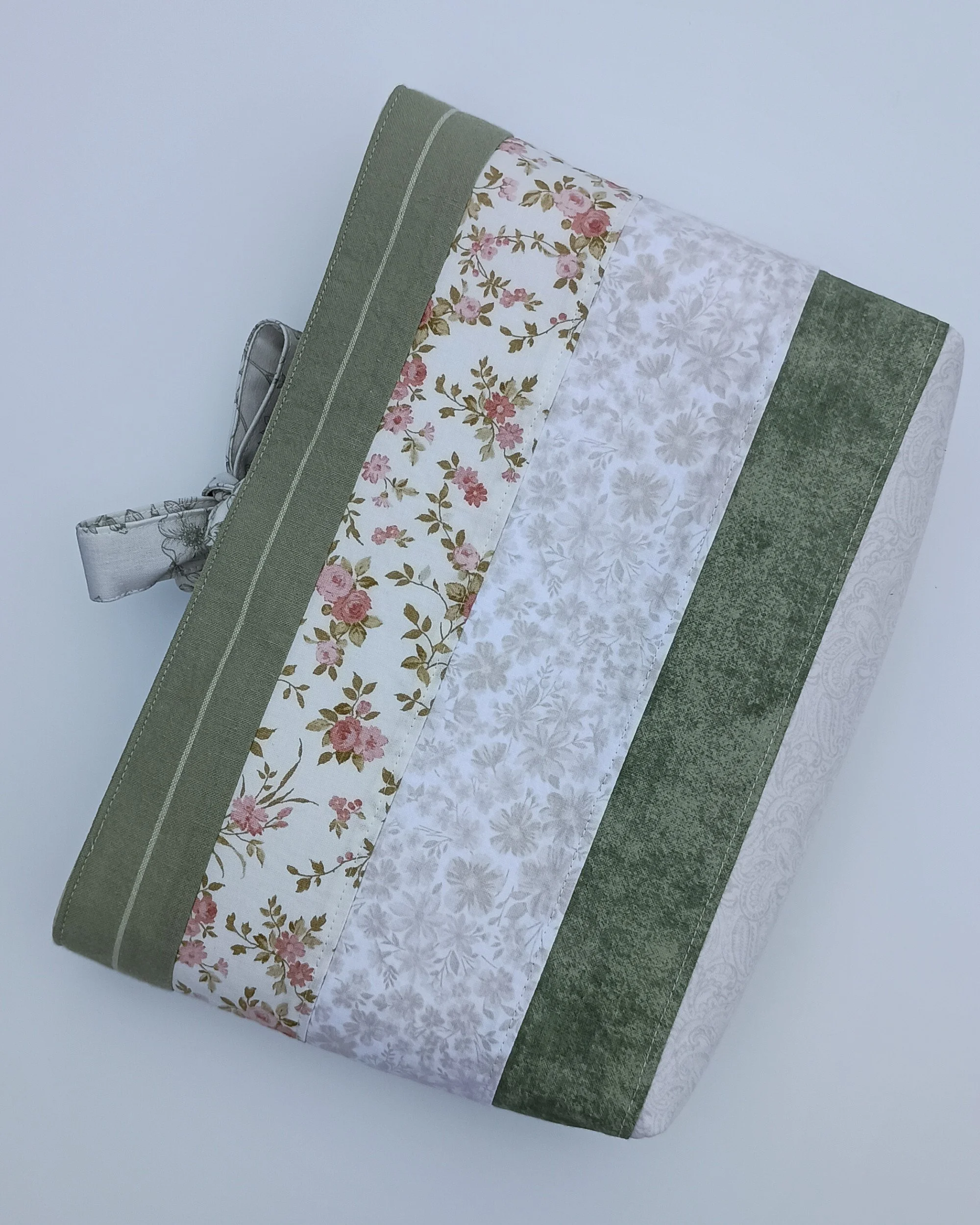 A quilted Bible Sleeve made from pink, sage, and beige fabrics
