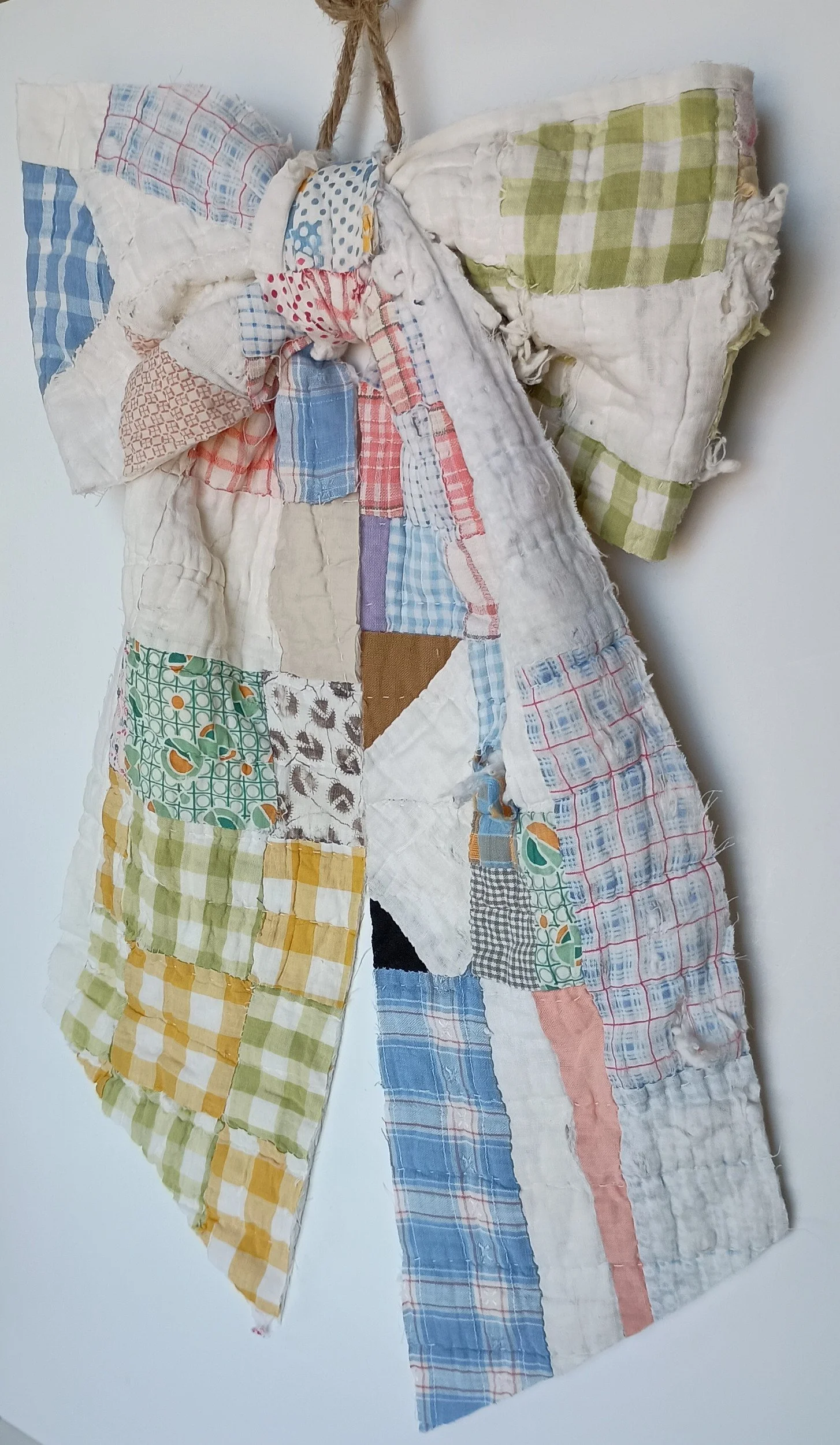 A decorative bow made from a tattered antique quilt