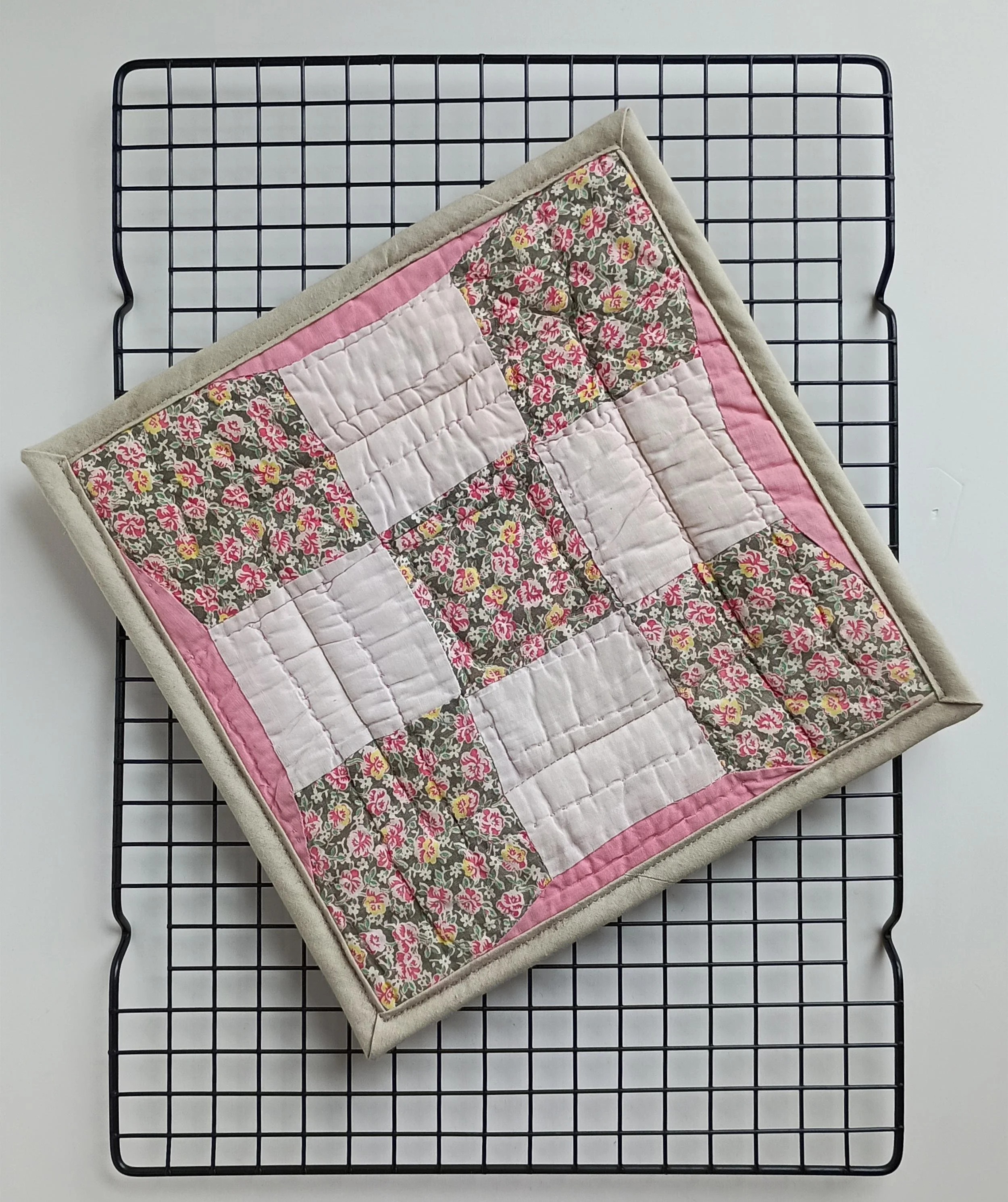 A hot pad made from an antique quilt square