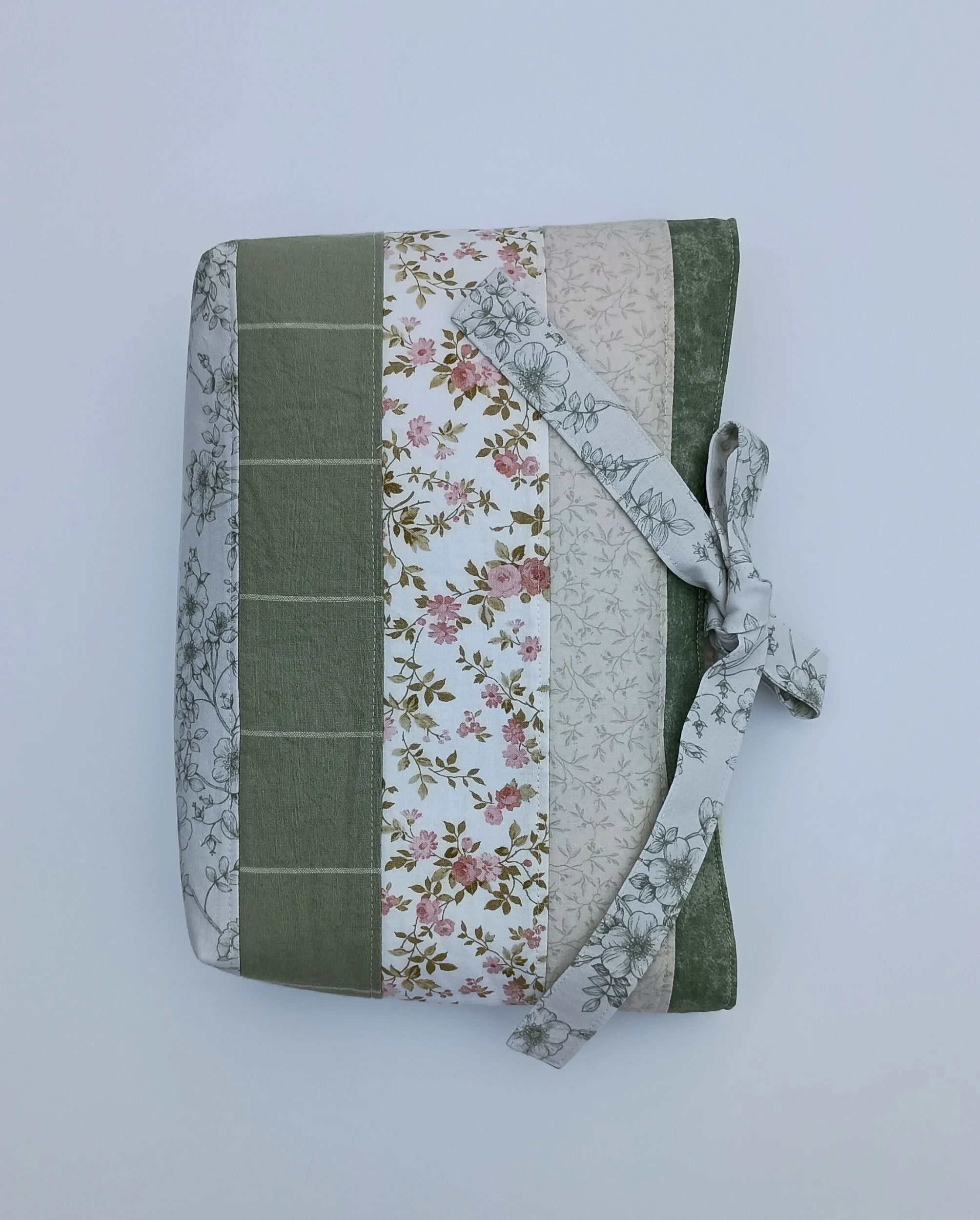 A quilted Bible Sleeve made from pink, sage, and beige fabrics