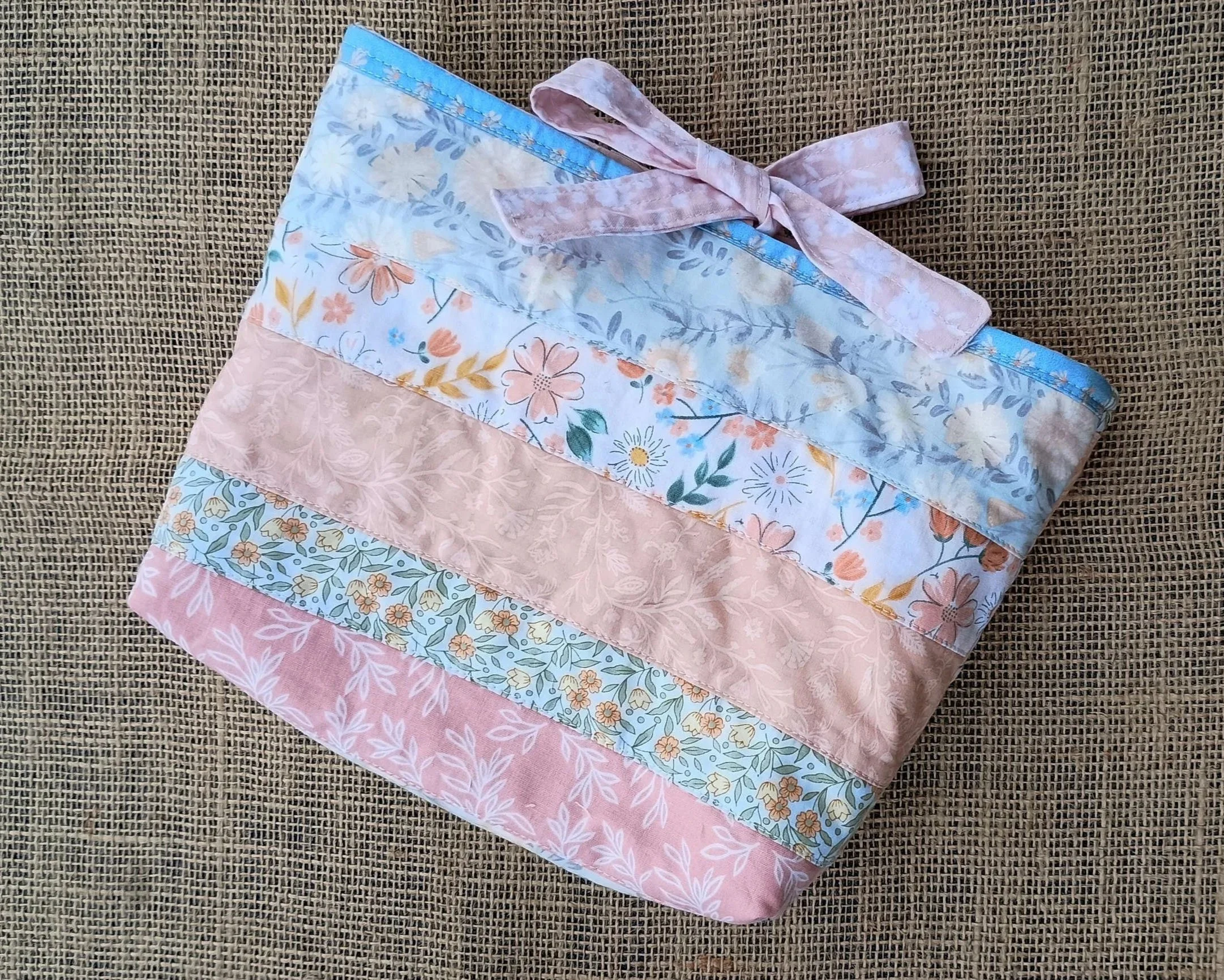 A quilted Bible Sleeve made from peach, green, and blue floral fabrics