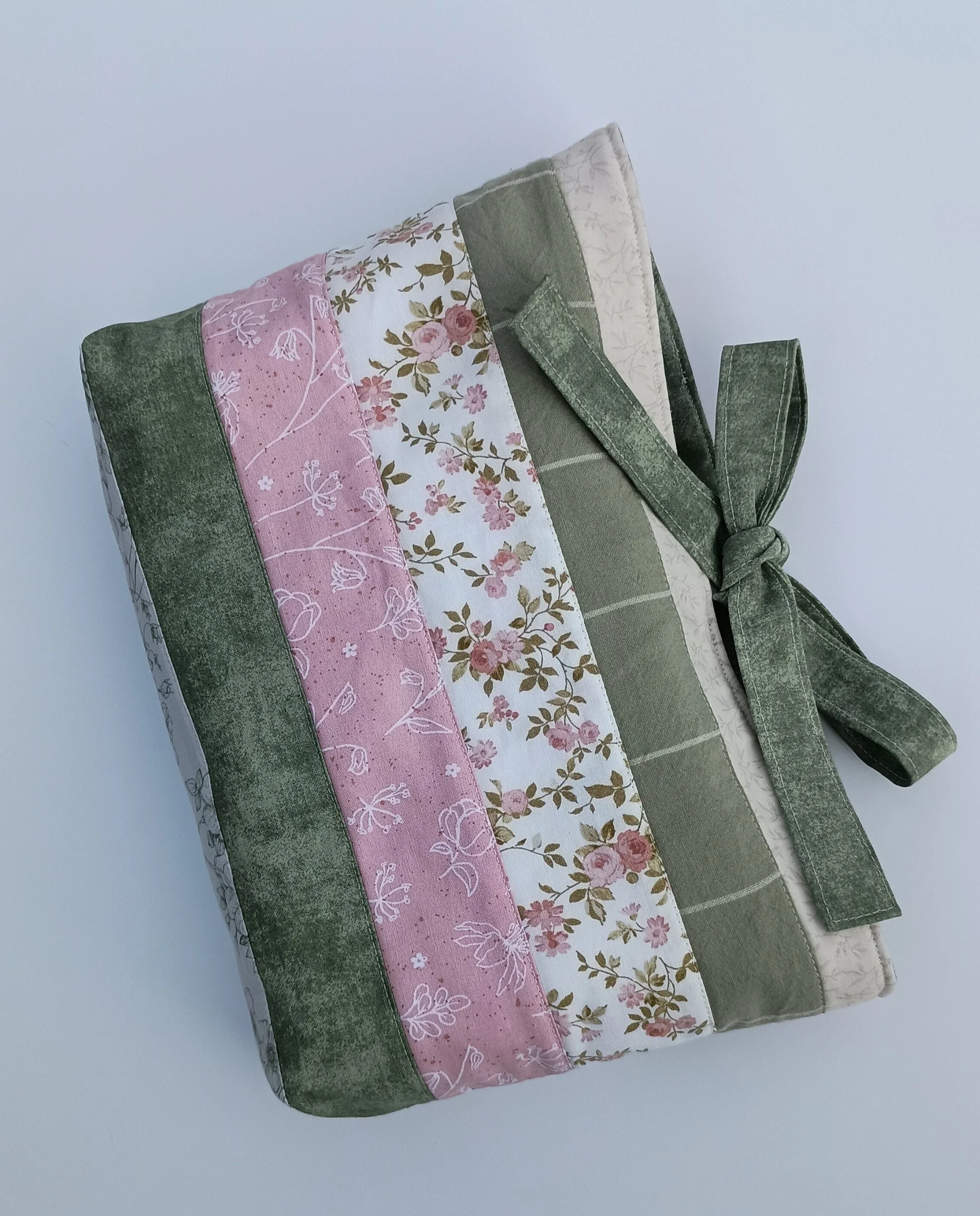 A quilted Bible Sleeve made from sage, pink, and beige fabrics