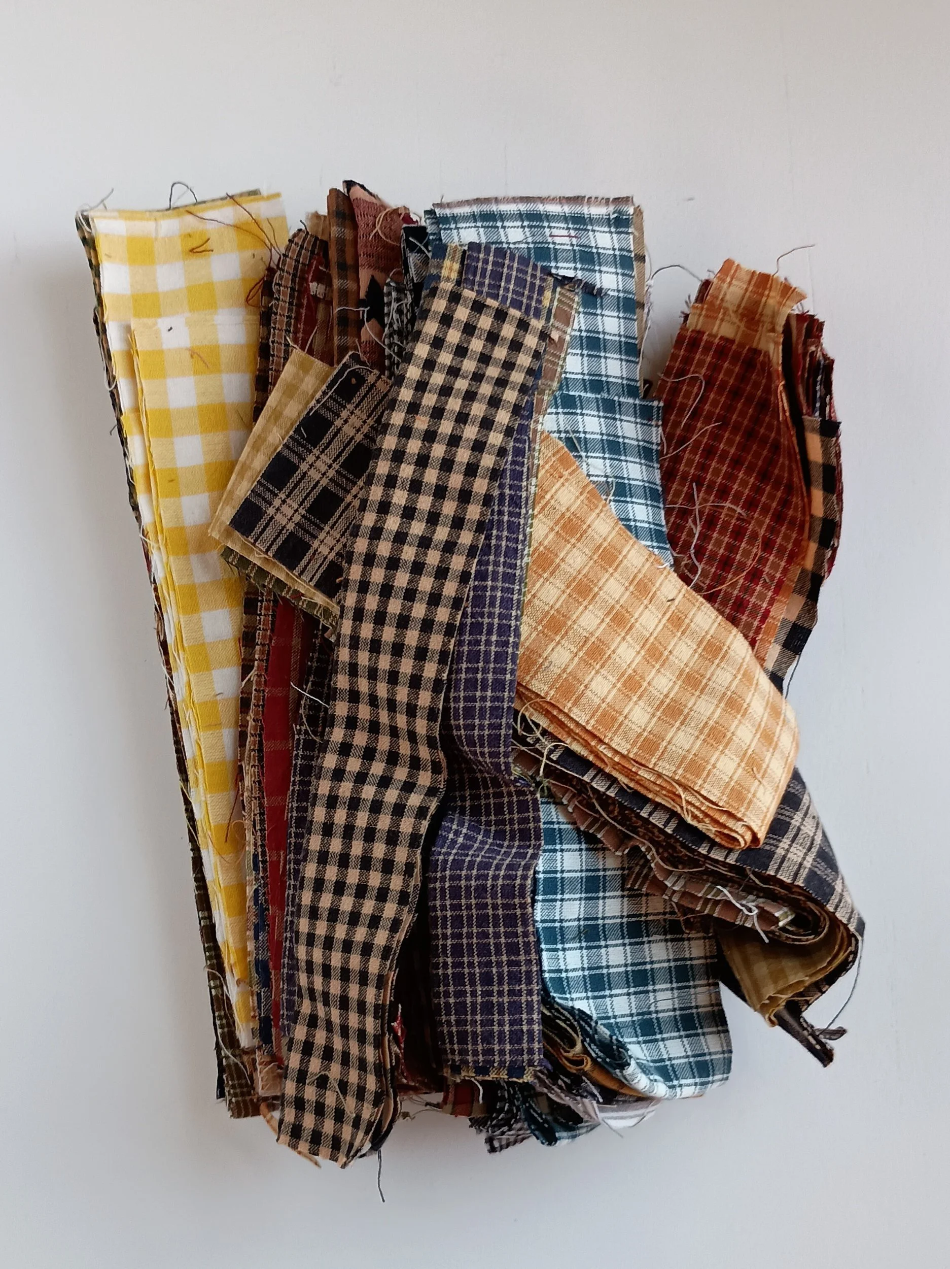 A pile of strips and scraps of homespun fabric