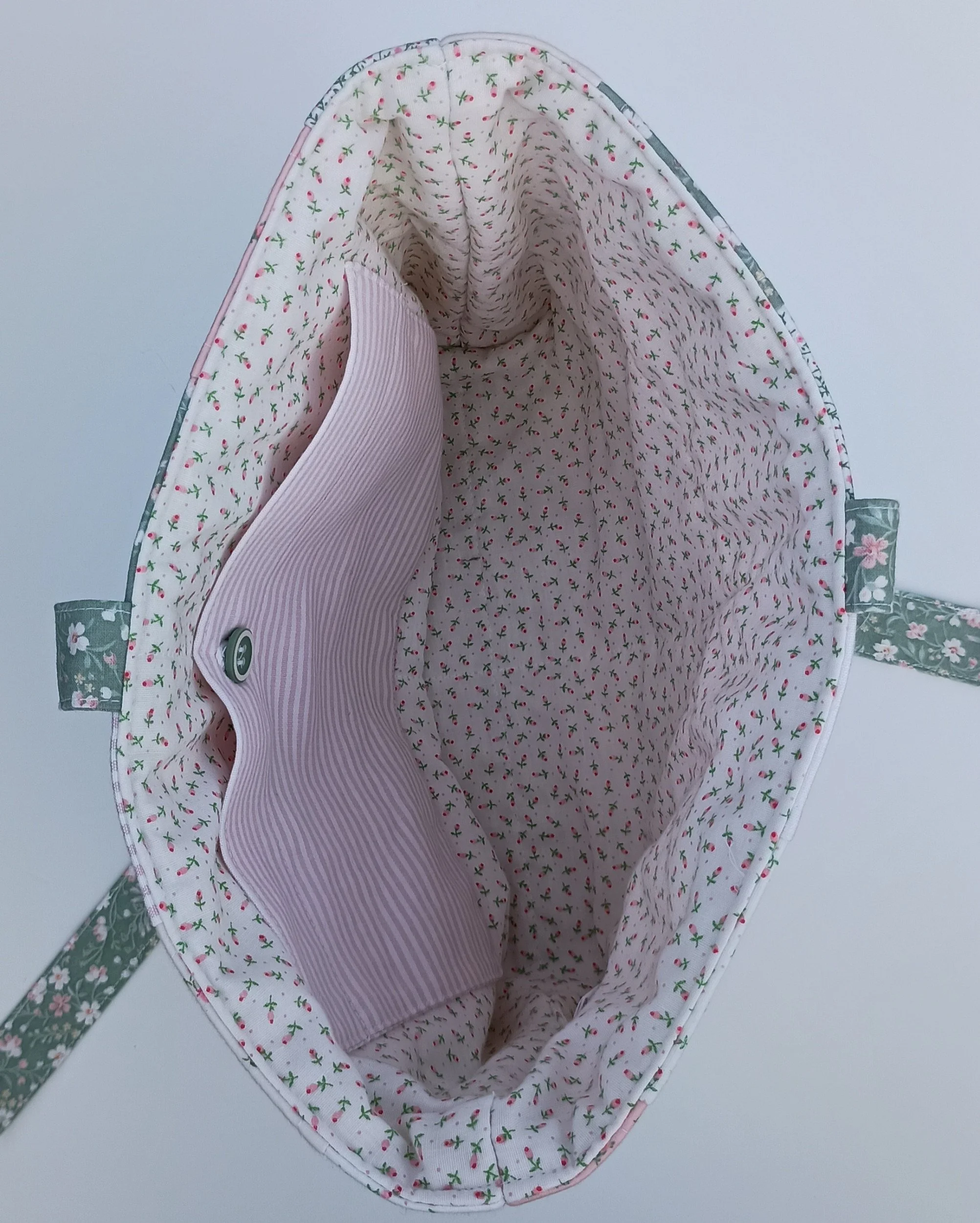 An inside view of a quilted Bible Sleeve made from pink and green fabrics