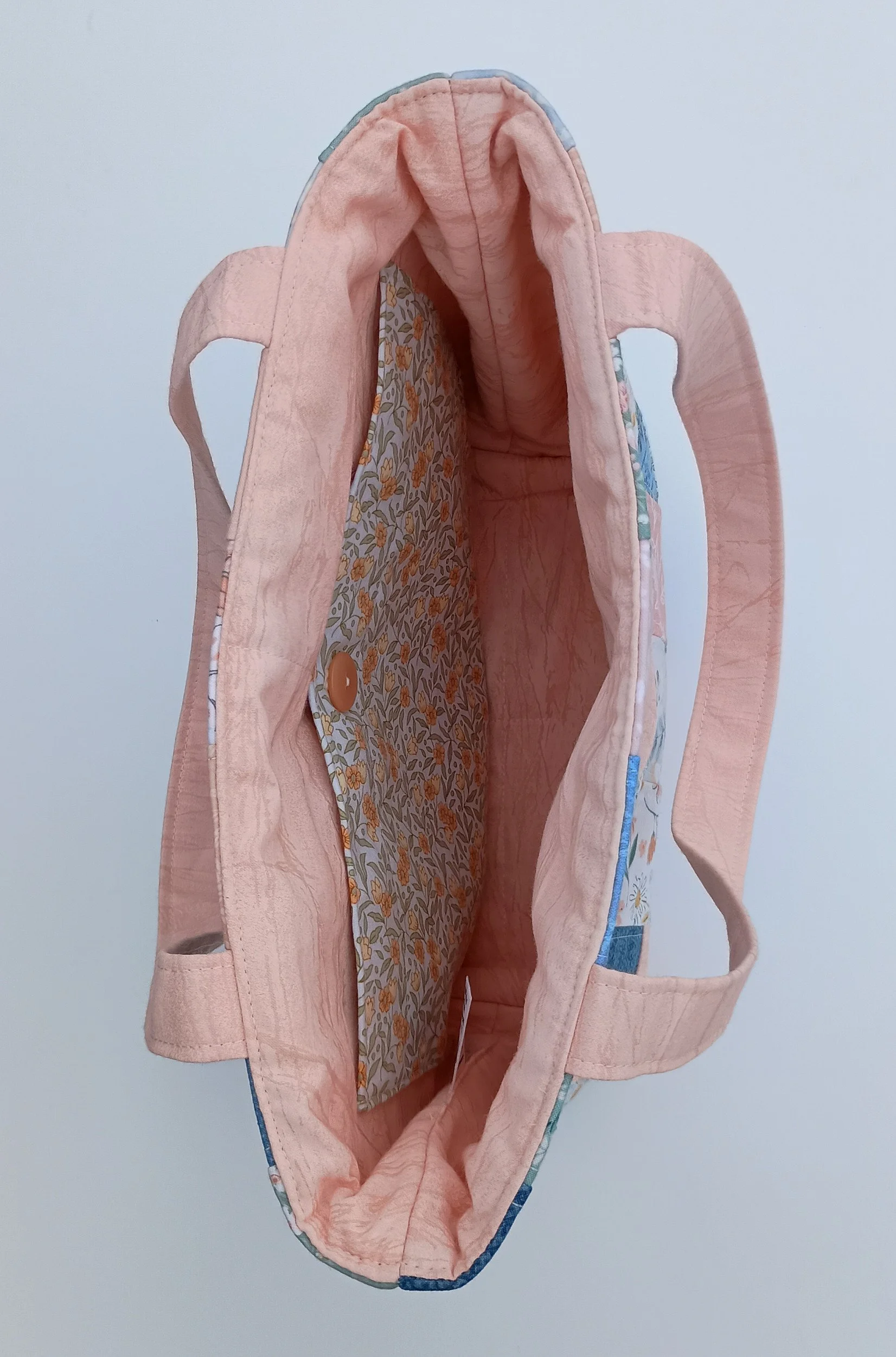 A quilted patchwork Bible Bag made from peach, green, and blue fabrics