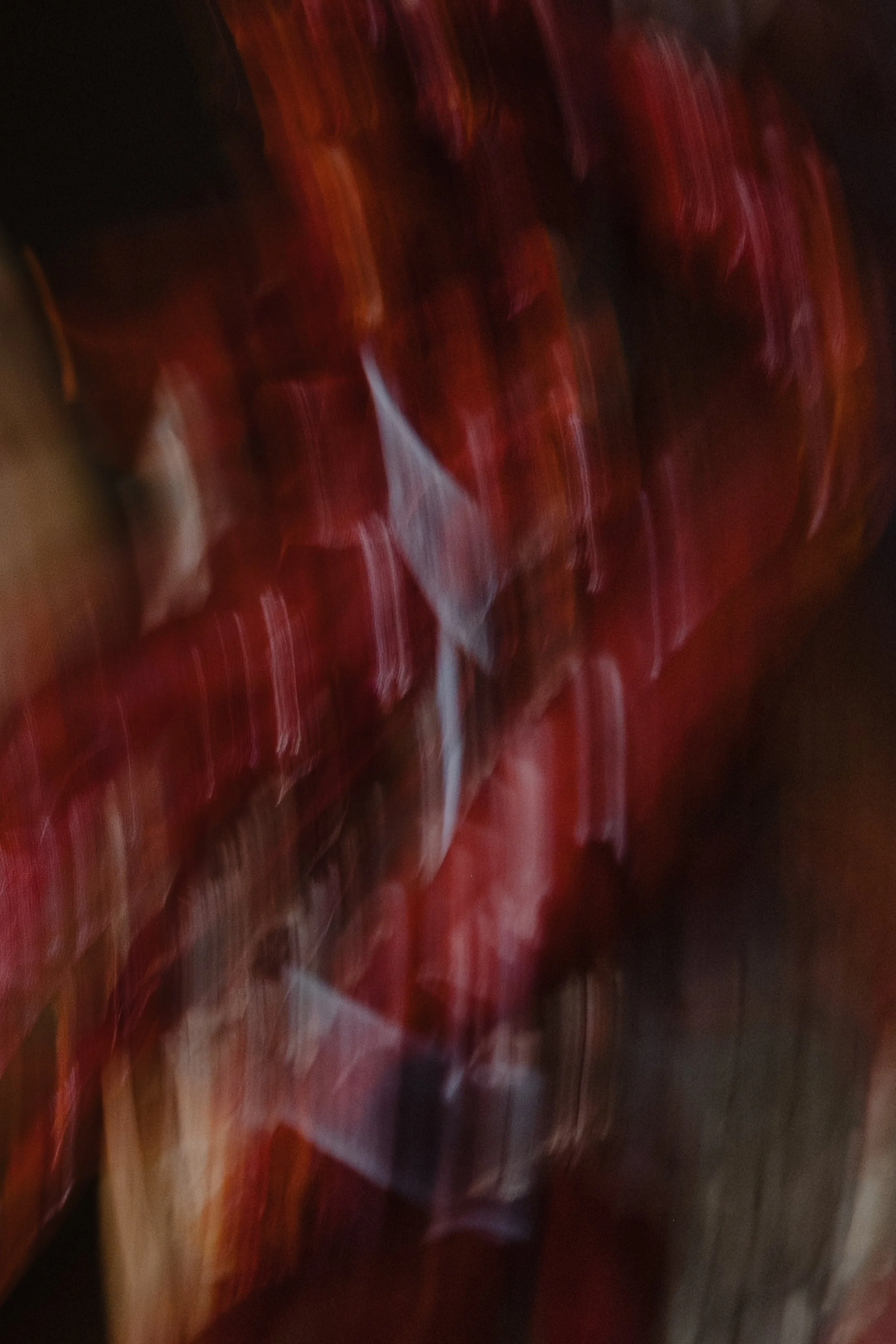 Blurry image showing red objects, possibly packaged food or products, with some white and darker areas.