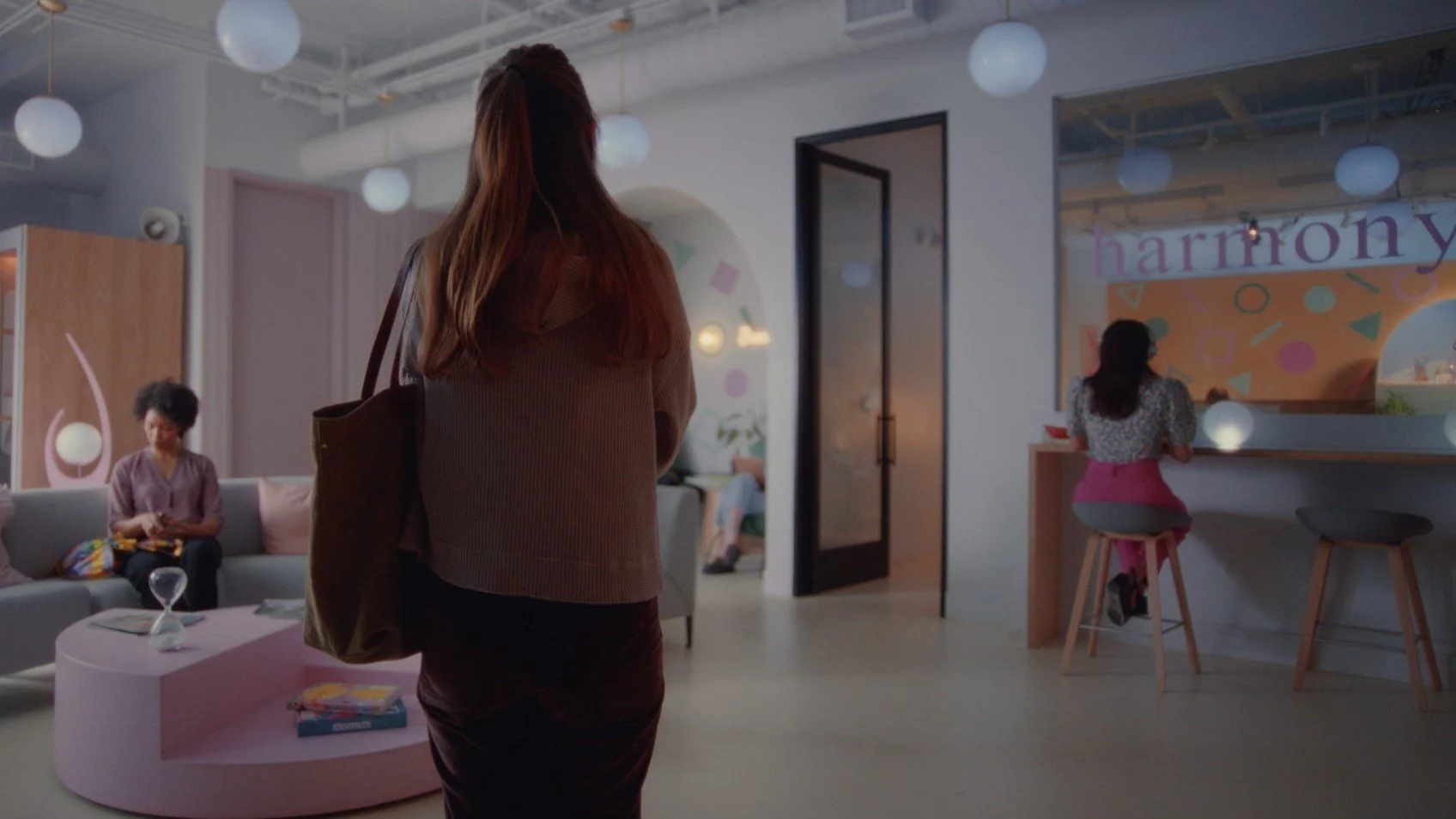 Still from the short film, HARMONY. Features the protagonist (Ahna O'Reilly) in a modern office's waiting room.