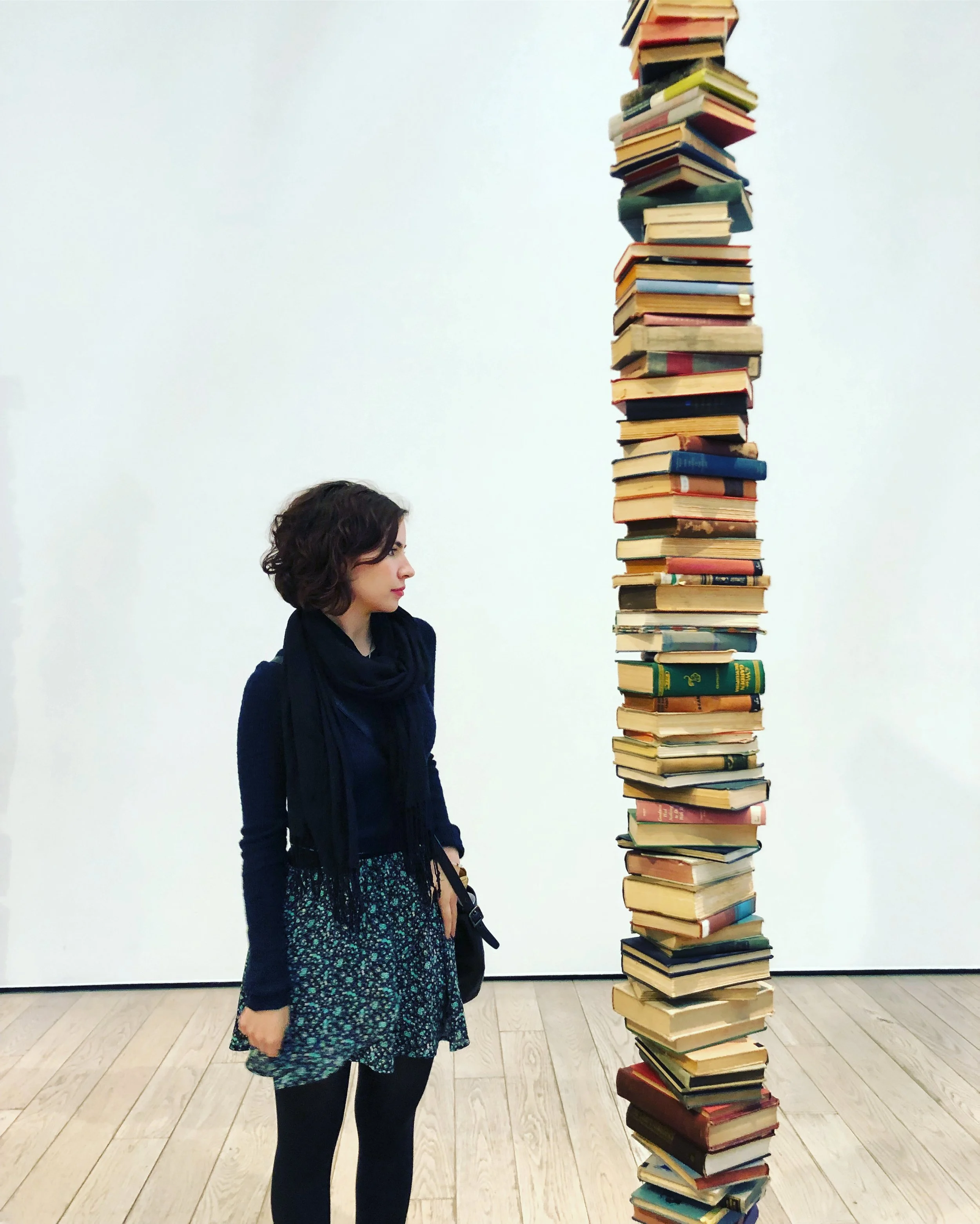 Nicole Smolen stands next to the art piece, The 1/4 Mile or 2 Furlong Piece (1981–98) by Robert Rauschenberg.