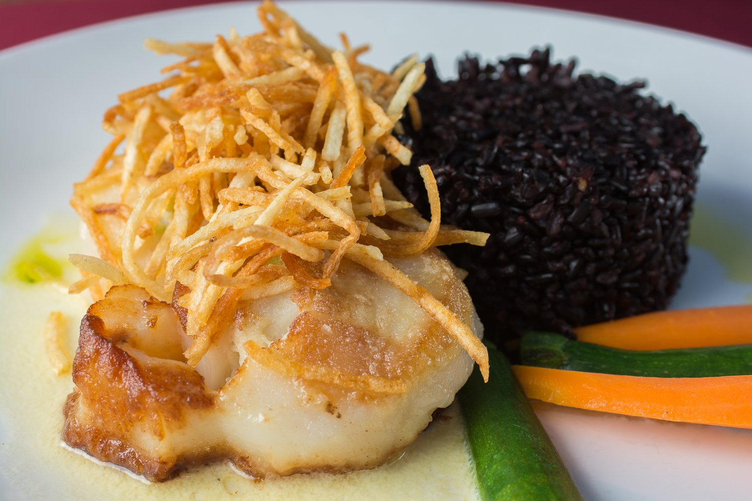 Pan-seared Scallops topped with shoestring potatoes and served with black rice and vegetables at Metropolitan Cafe in Downtown Freehold, New Jersey