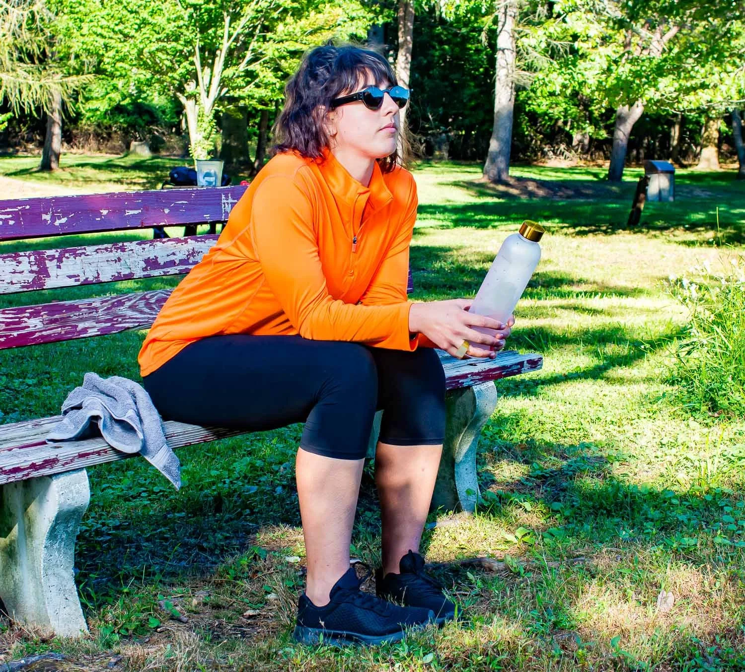 Young female octapharma WILATE patient resting after exercise on a park bench on a sunny day