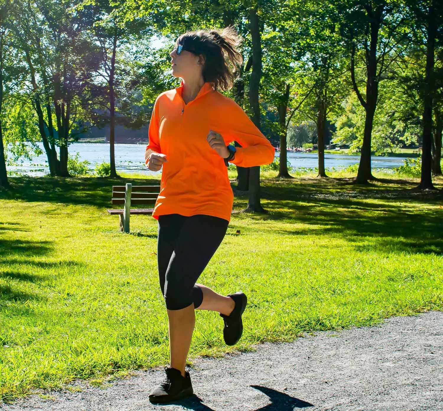 Young female octapharma WILATE patient engaging in running exercise in a park setting on a sunny day-alternate photo