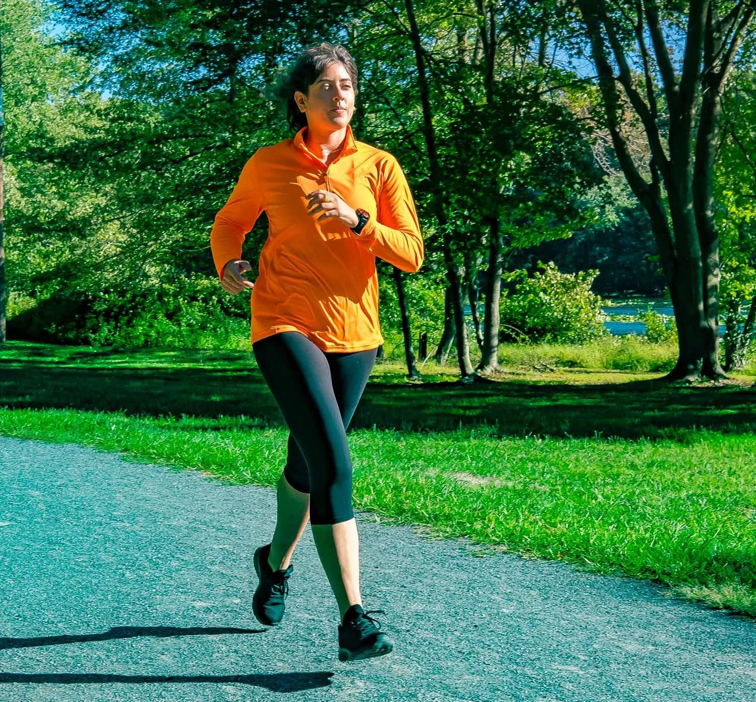 Young female octapharma WILATE patient engaging in running exercise in a park setting on a sunny day