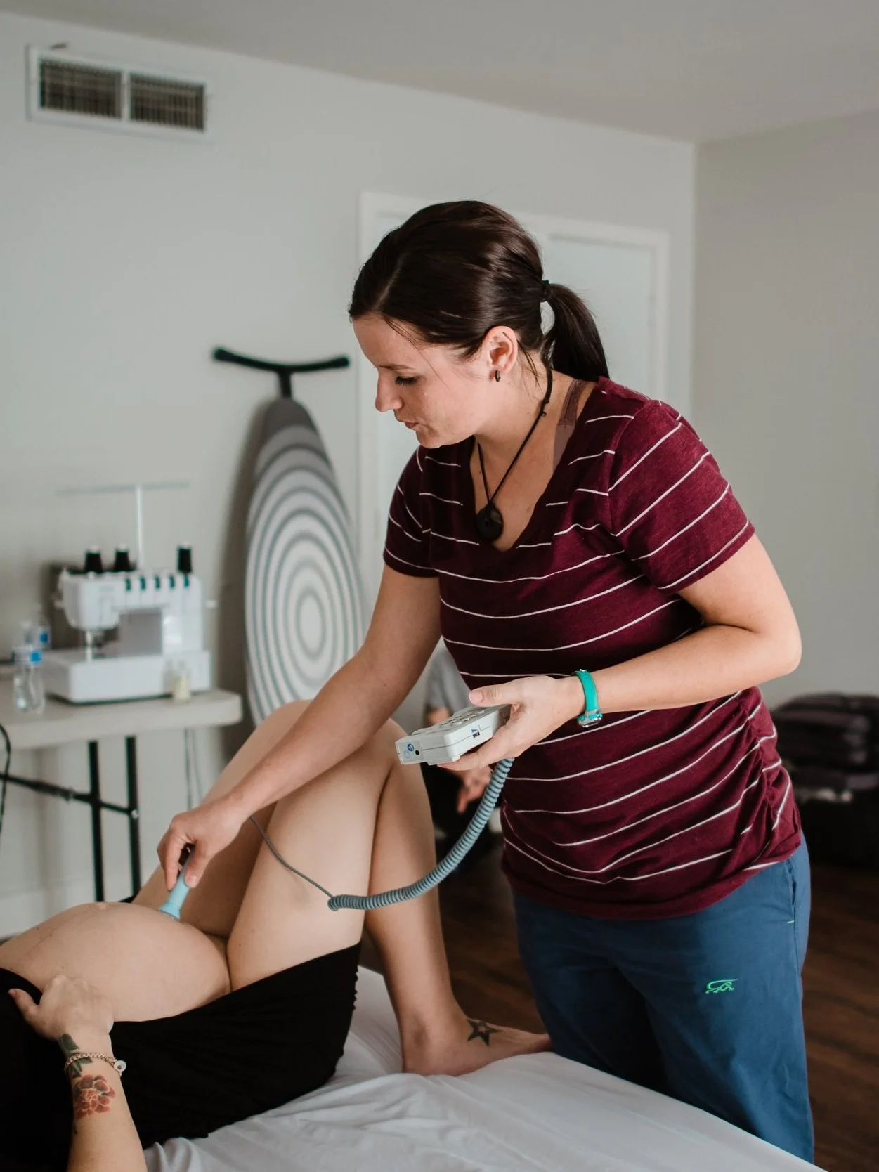 Midwife listening to fetal heart beat at home birth