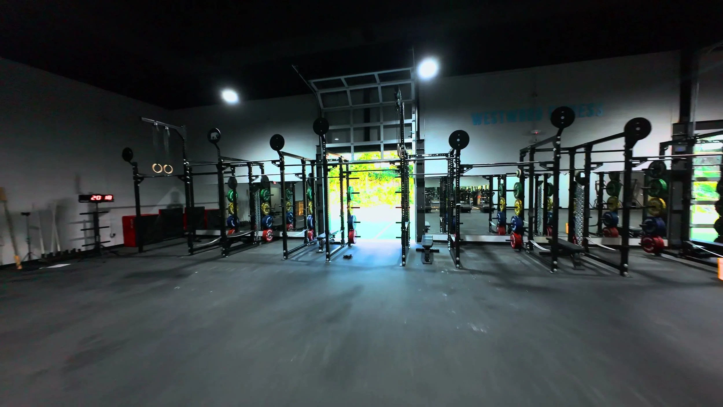 Rows of squat racks loaded with colour-coded bumper plates