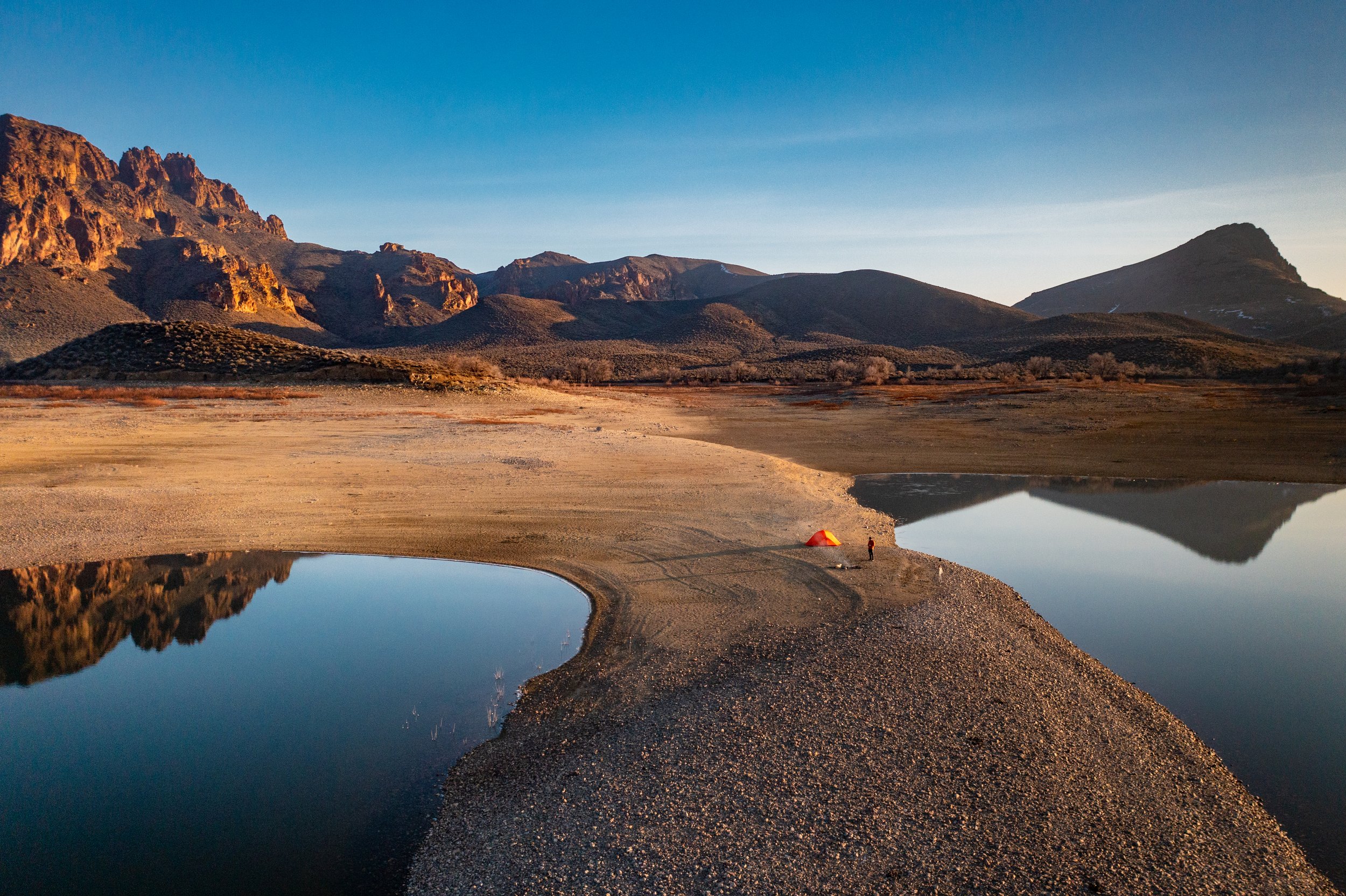Aerial drone photograph of a solo tent camped in the Owyhee Mountains of southwestern Idaho, captured by Jon Conti Visuals. This 5K image shows the rugged desert terrain, soft evening light, and sense of solitude that defines Idaho’s remote backcount