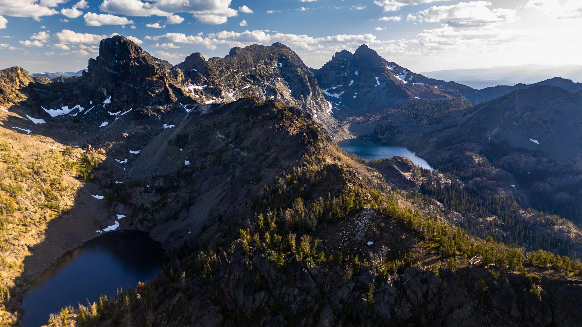 Aerial drone photograph of the Seven Devils Mountains in western Idaho, captured at sunset by Jon Conti Visuals. This 5K image shows rugged peaks glowing in warm evening light above Hells Canyon — a striking view of Idaho’s remote backcountry and one