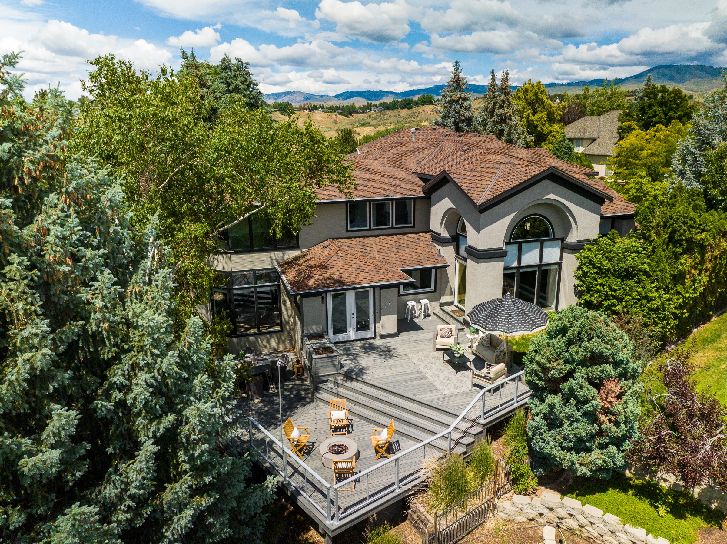 Aerial drone photo of a luxury home in the Boise foothills, showing city views and surrounding landscape.