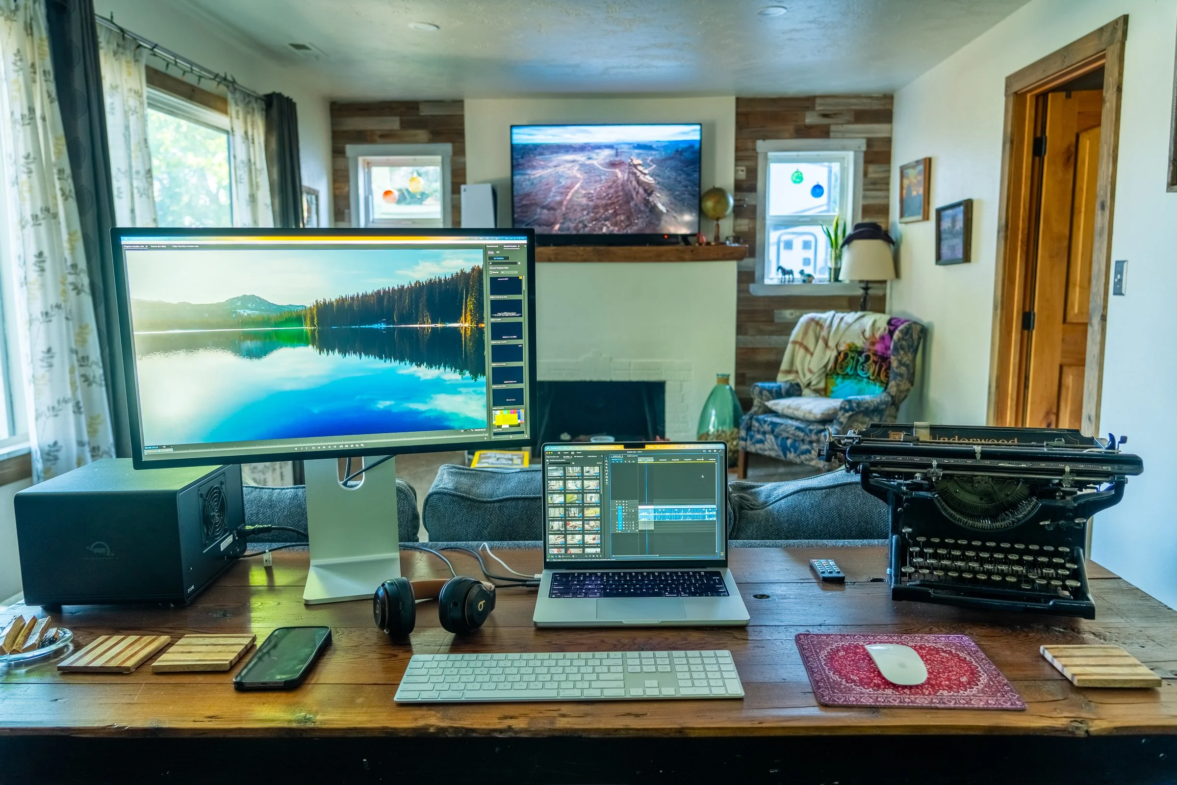 Home workstation of a solo business owner with dual monitors, laptop, and editing setup.