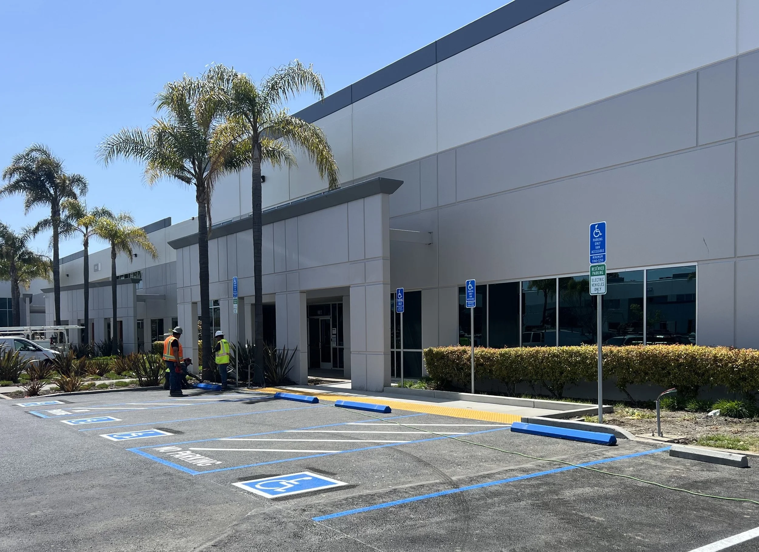 Fremont, CA — Concrete entry walkway and curb ramps connecting accessible parking to a commercial building.