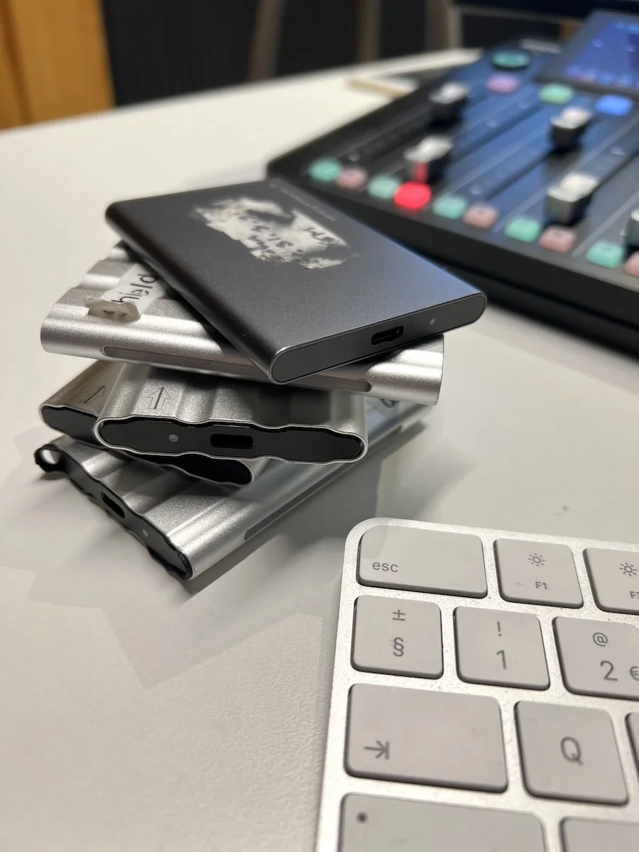 A stack of SSDs containing video content waiting to be edited.