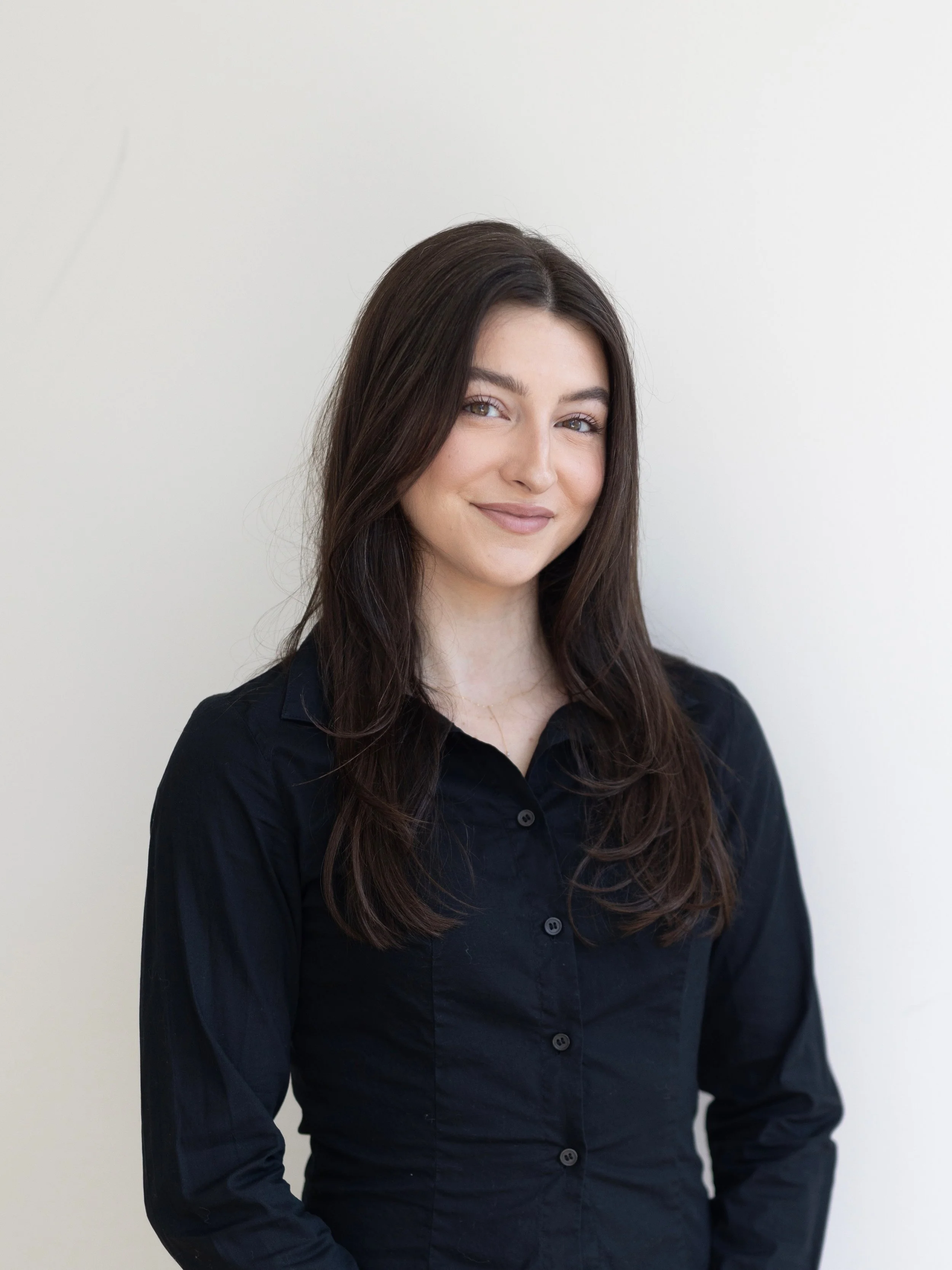 Executive styling assistant Sophia Henry of Good Lines Styling posing for headshot in black button down tailored shirt