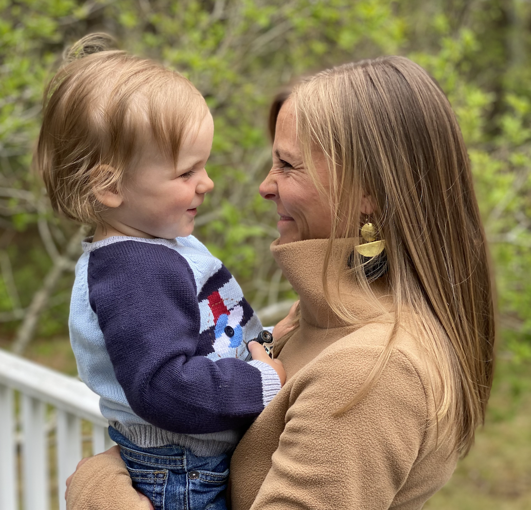 Mother and son smiling at each other while standing outside