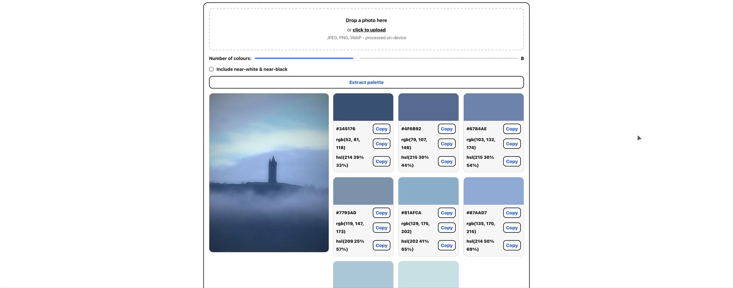 A screenshot of a color palette generator webpage displaying a blue-toned photograph of a foggy landscape with a tall, narrow tower visible in the distance. The webpage shows various shades of blue with their corresponding hex, RGB, and HSL color codes, and options to copy each color.