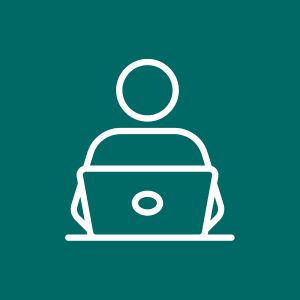 Icon of a person sitting at a desk using a laptop