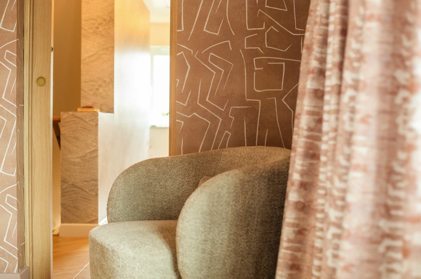 Textured armchair and soft rug in Shelford master bedroom, designed as a quiet seating retreat.