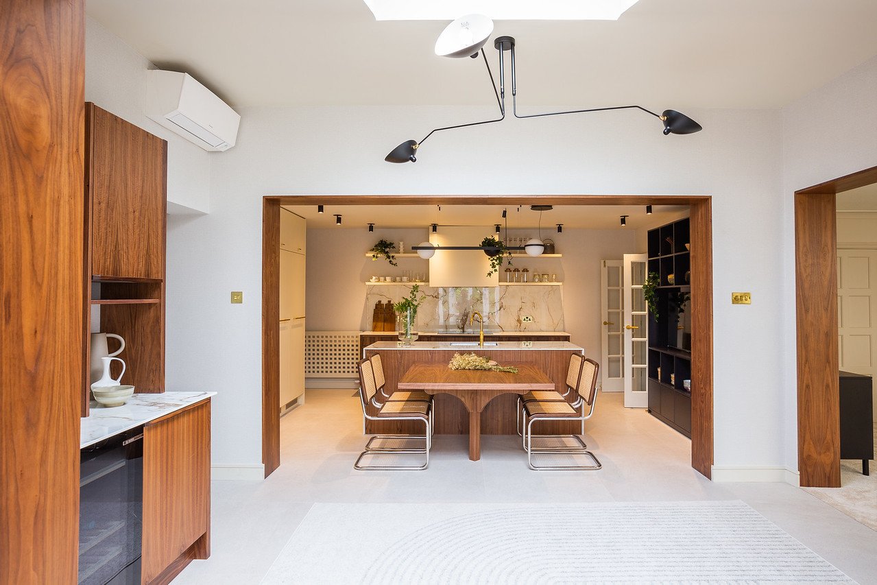 Open‑plan kitchen and dining space in Gamlingay with four entry points to adjoining rooms, showing how circulation shaped the final layout