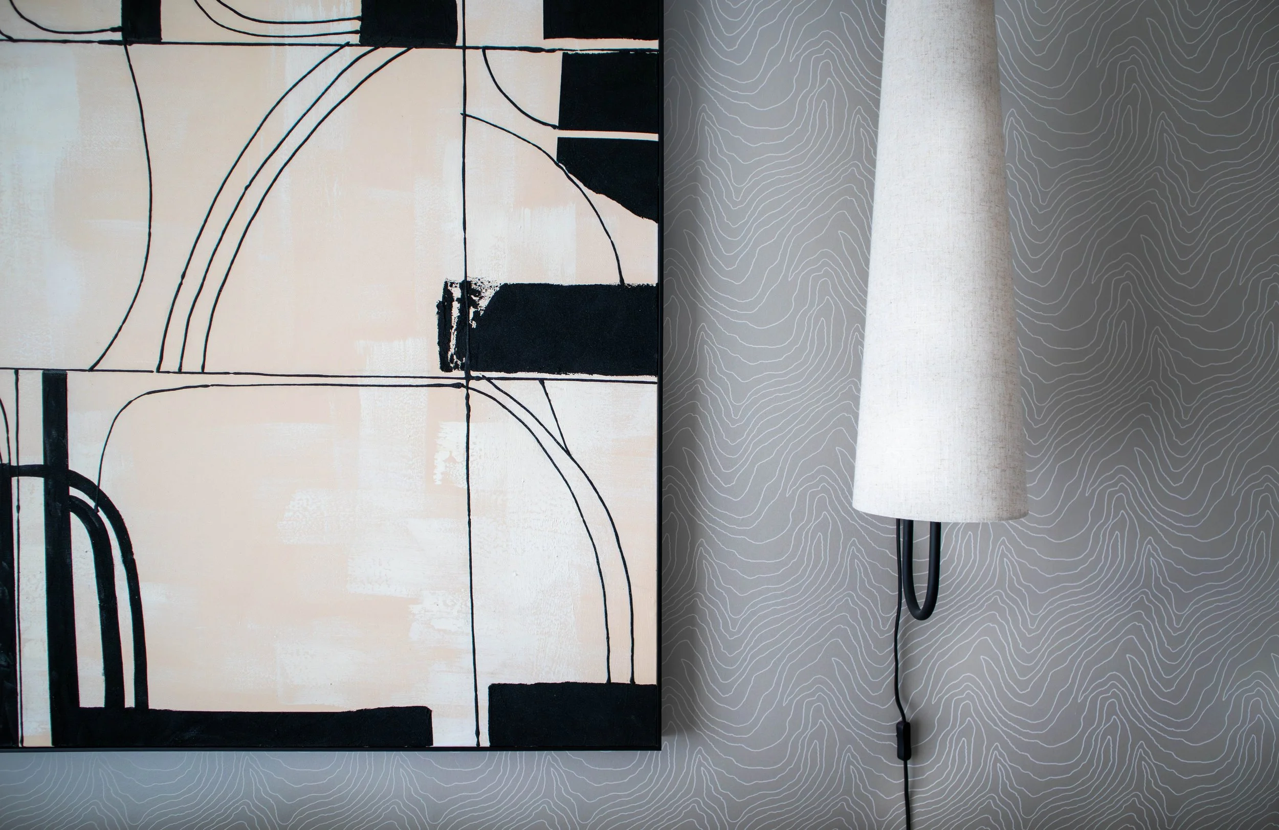 Section of the bespoke artwork above the Water Lane sofa, shown alongside the Ferm Living wall light against the softly textured wall surface