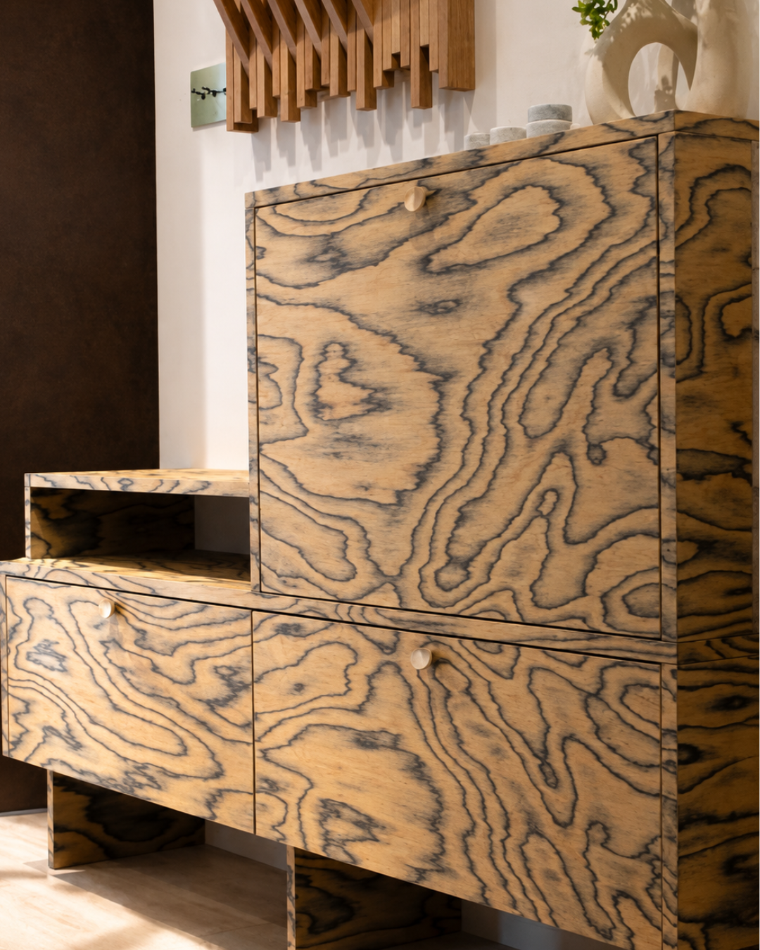 Bespoke hallway storage designed by Pinterior.space for the Shelford Project, combining expressive timber grain with integrated shoe storage, concealed cabinetry and handcrafted detailing.