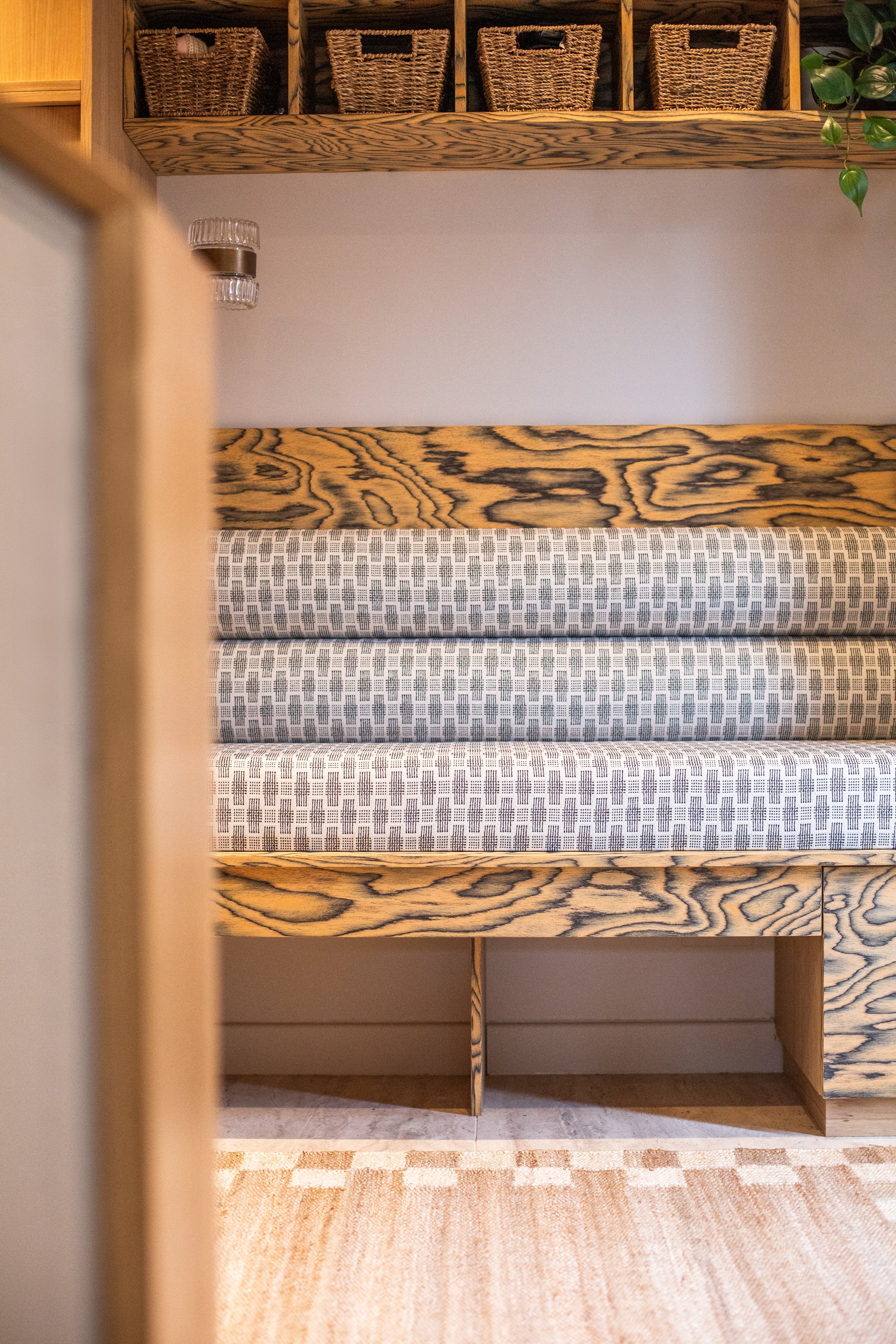Shelford Hallway interior detail — Nordic Scandinavian Modern style with built-in wood bench, geometric cushions, woven baskets, soft lighting, and natural textures.